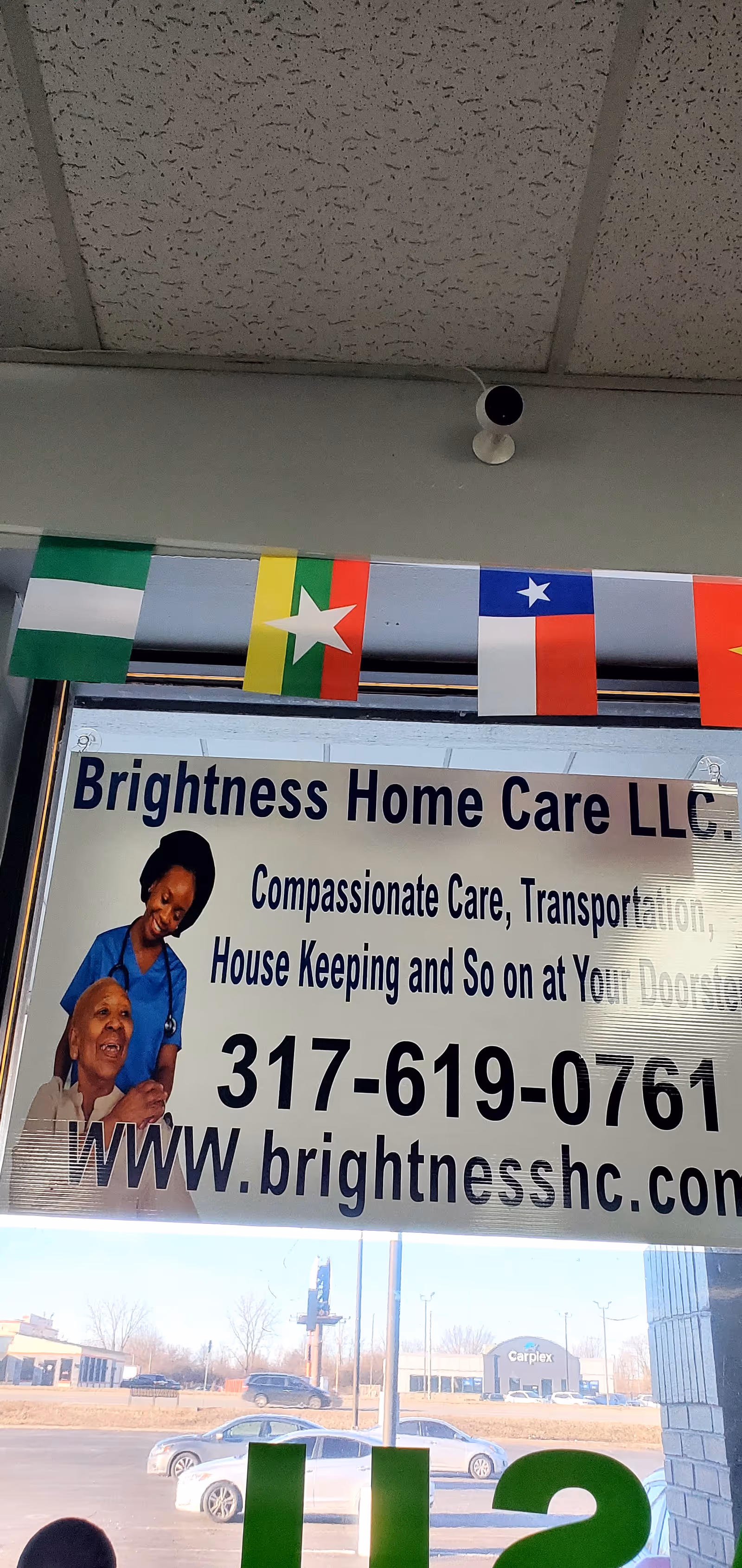 Entrance sign for Brightness Home Care LLC with phone number and caregiver image.