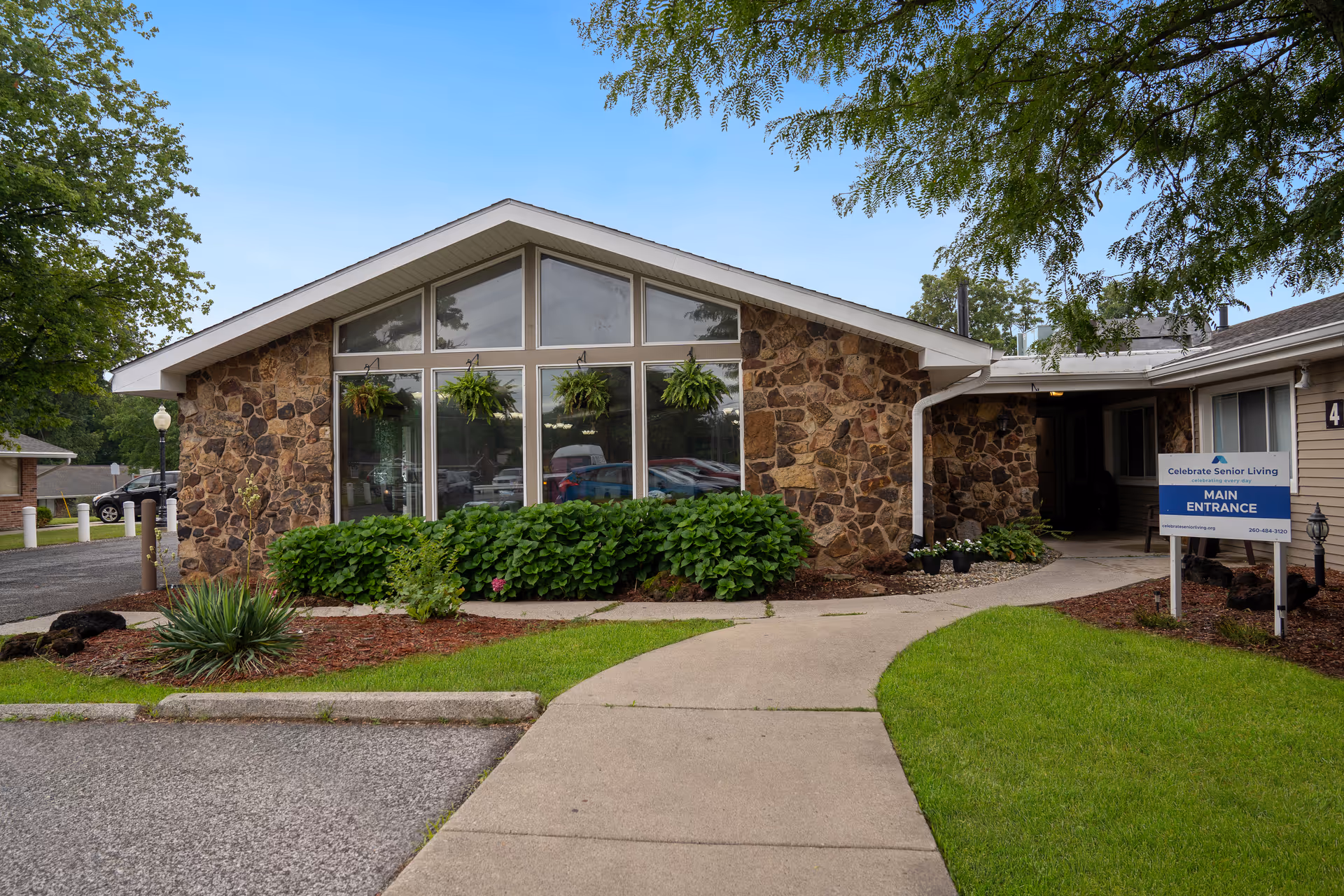 Senior living facility front entrance with stone exterior and landscaping