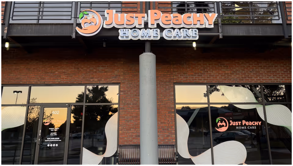 Exterior view of Just Peachy Home Care facility with glass doors and sign.