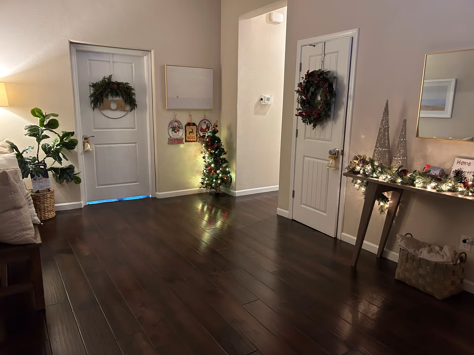 Decorated hallway in a senior living facility with Christmas garlands and a small tree.