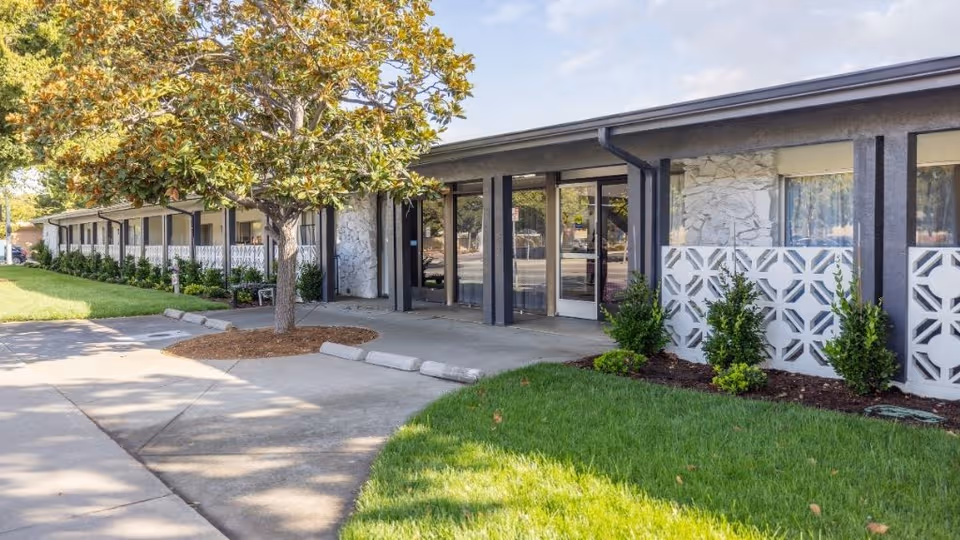 Exterior view of Canyon Springs Post-Acute entrance with glass doors and landscaping.