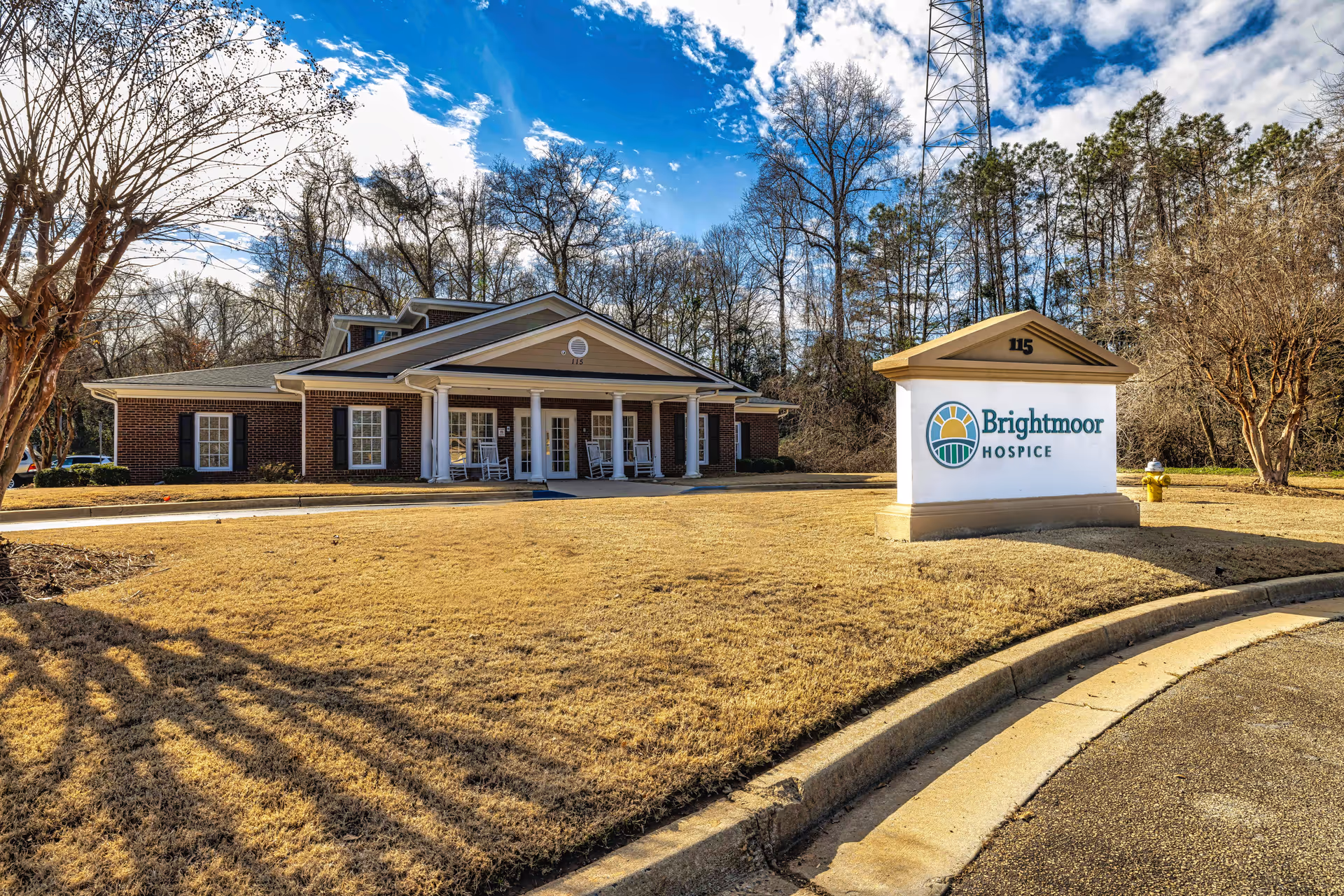 Exterior view of Brightmoor Hospice building with a sign and surrounding lawn.