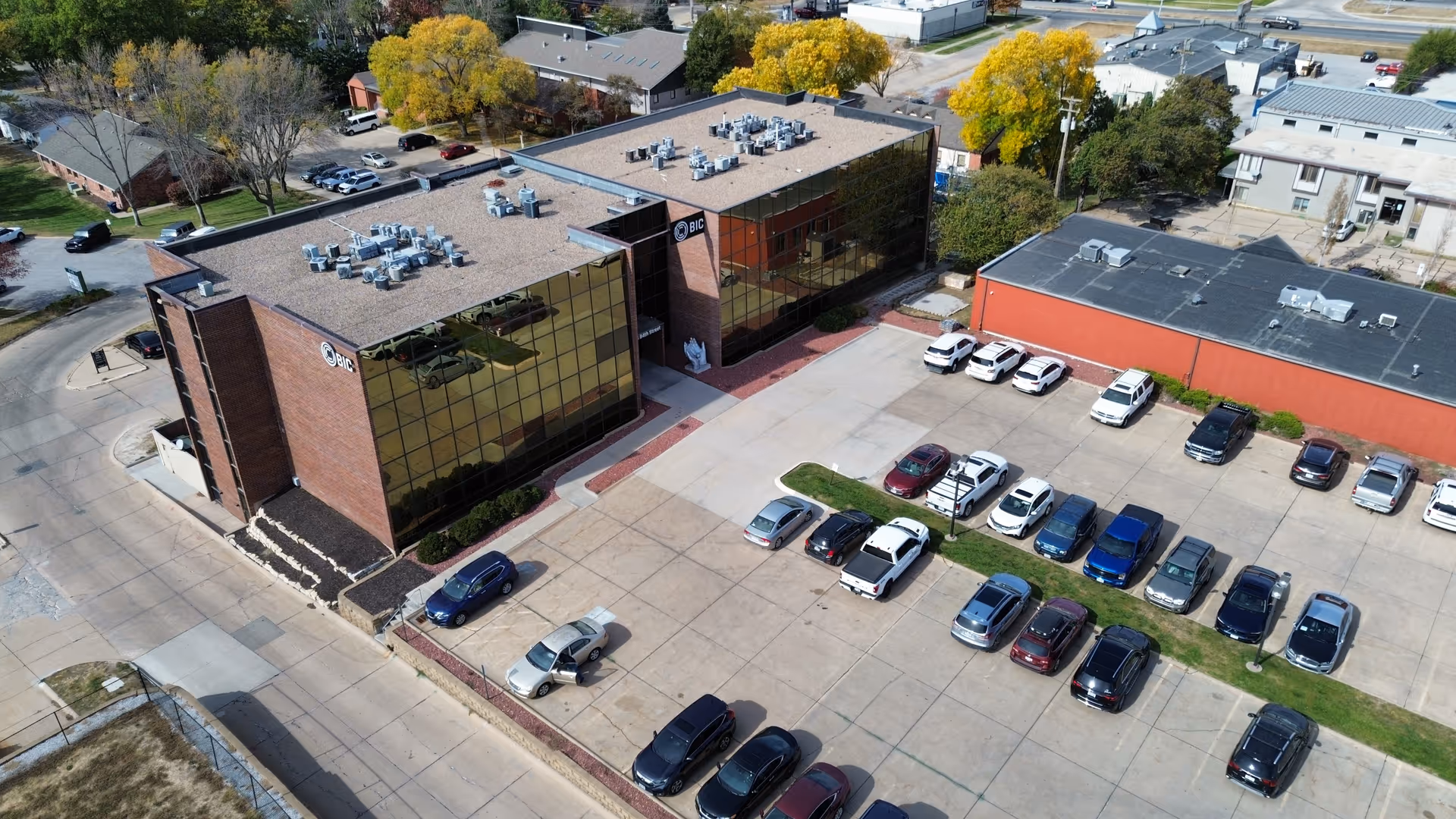 An aerial view of CHI Health at Home building with brick exterior and parked cars.