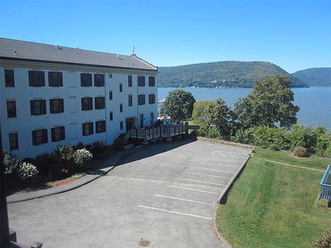 Villa St. Francis exterior: white multi-story building by a lake with parking and trees.