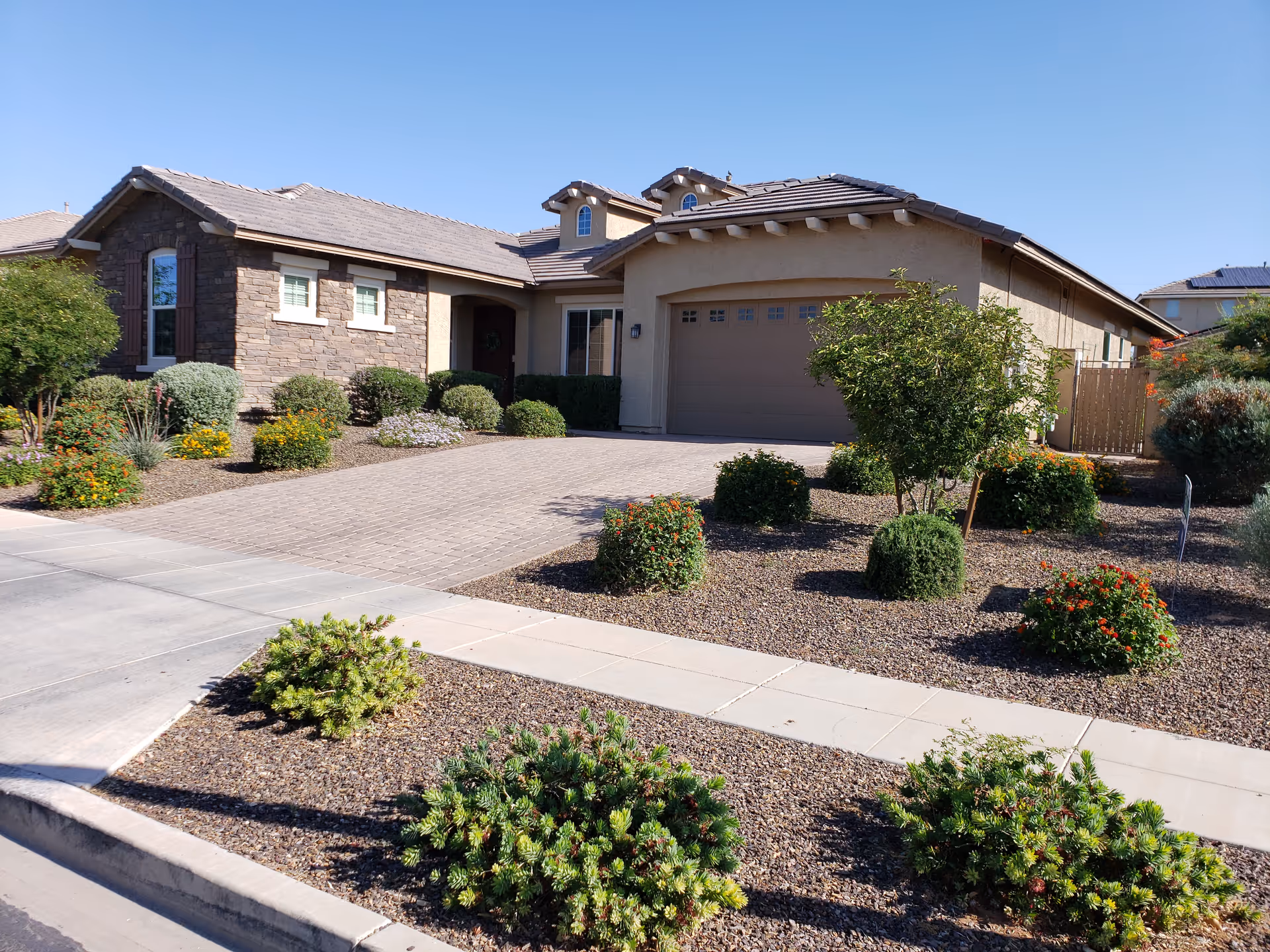 A single-story residential-style facility with a two-car garage, paved driveway, and desert landscaping.
