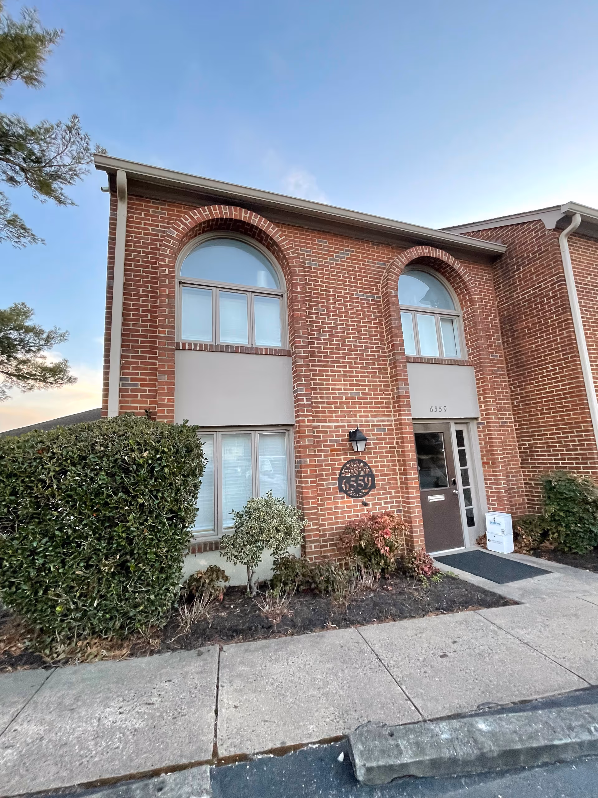 Brick building exterior with arched windows and an accessible front entrance