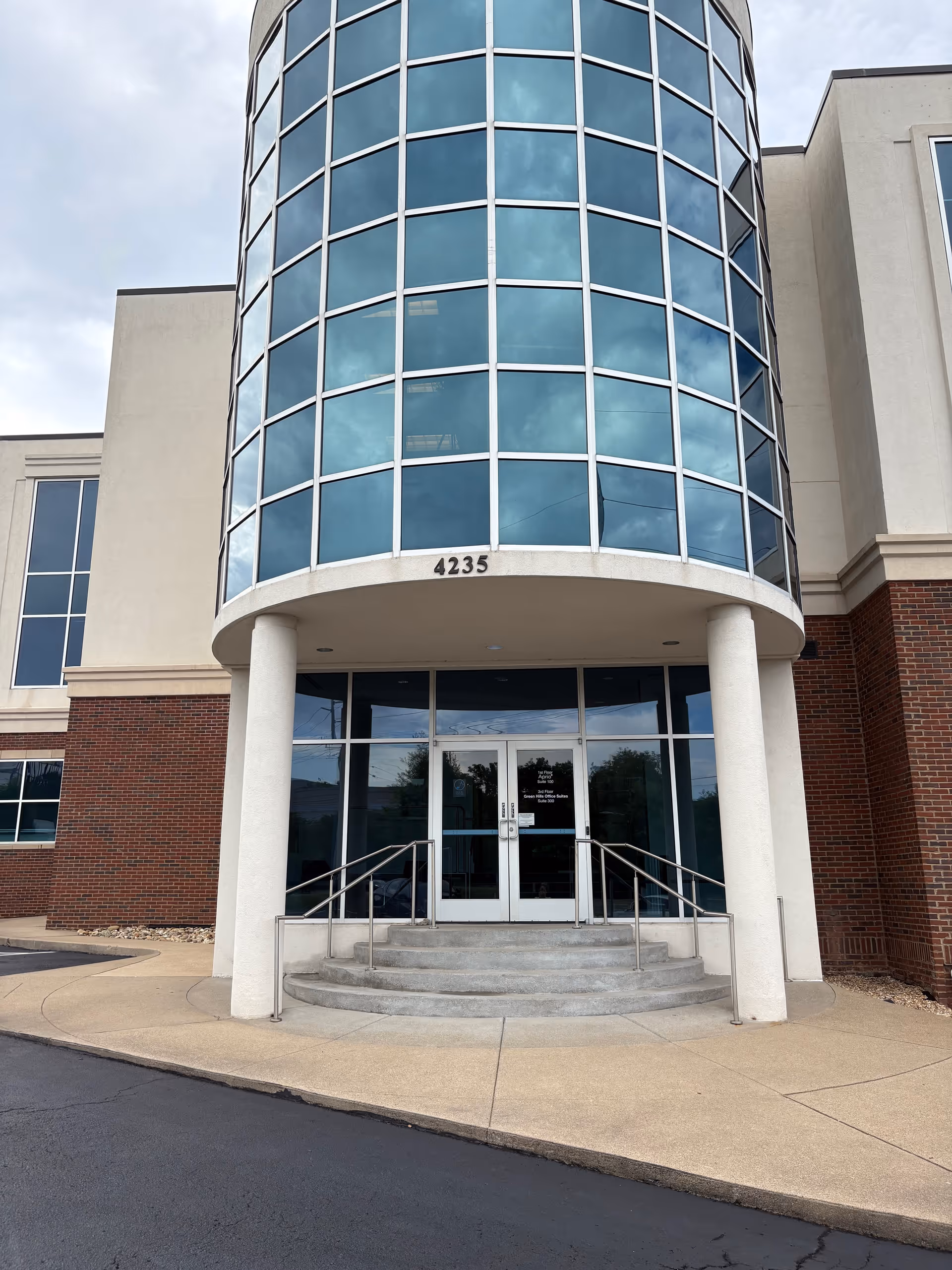 Curved glass front entrance of a modern senior facility at address 4235.