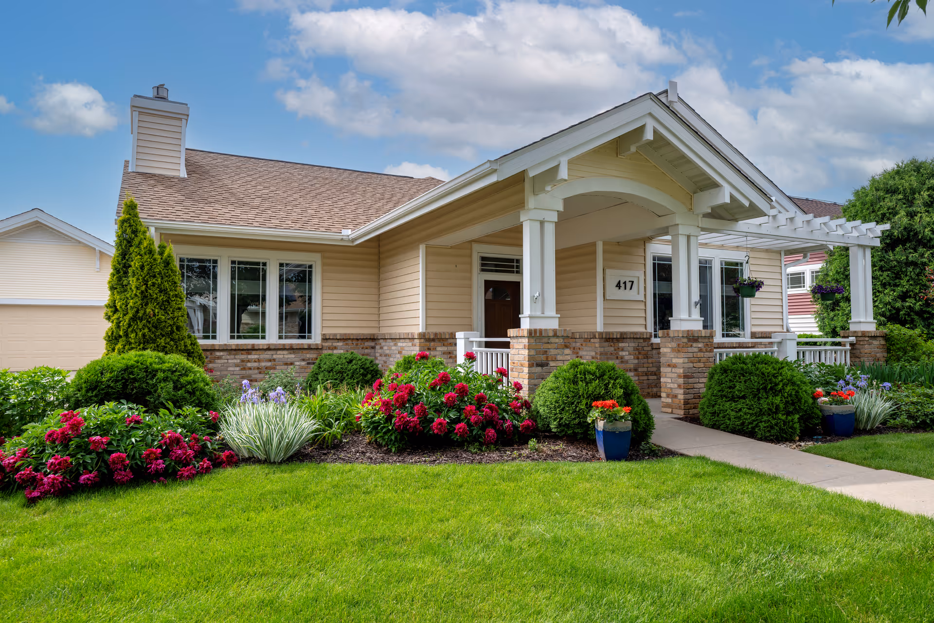 Front view of a single-story senior living facility with landscaped garden and porch.