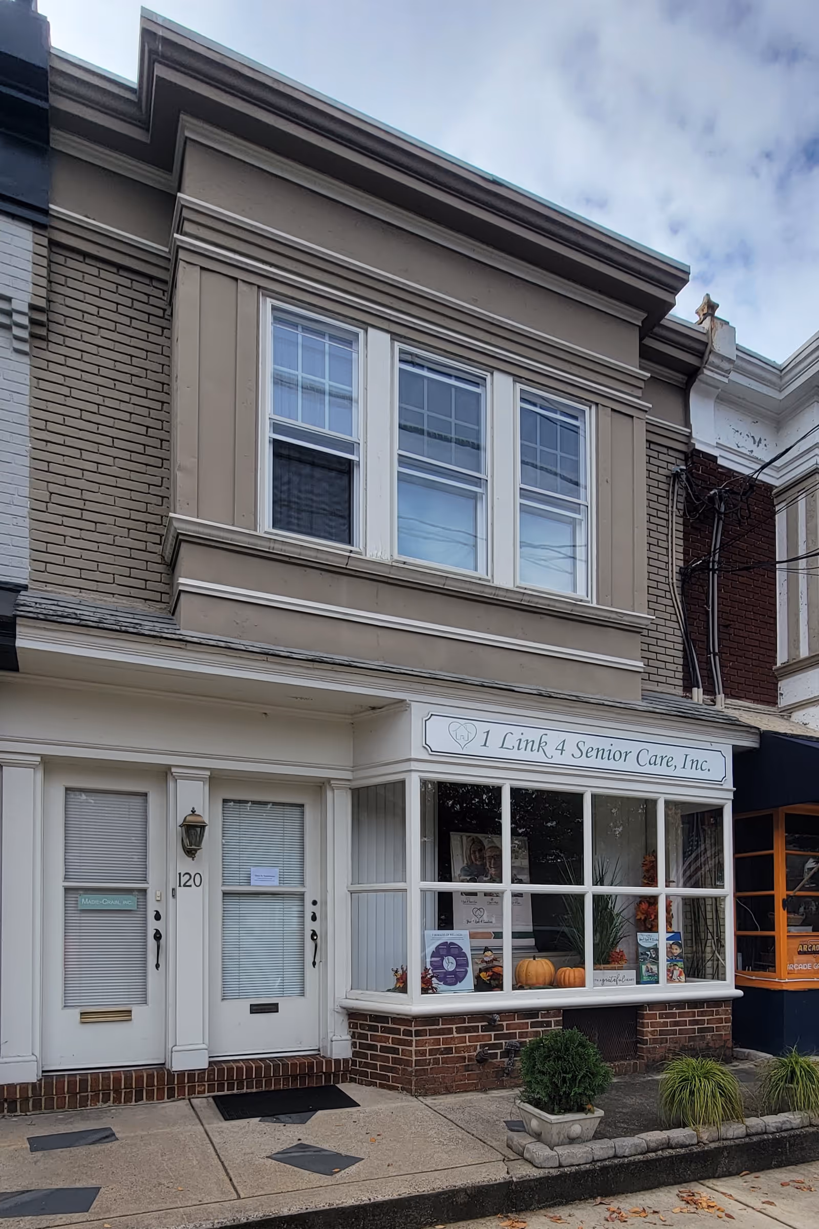 Front view of 1 Link 4 Senior Care storefront with pumpkins in the display window.