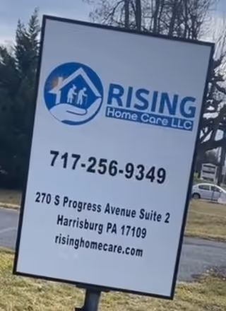 Outdoor sign for Rising Home Care LLC with logo, phone number, and address.