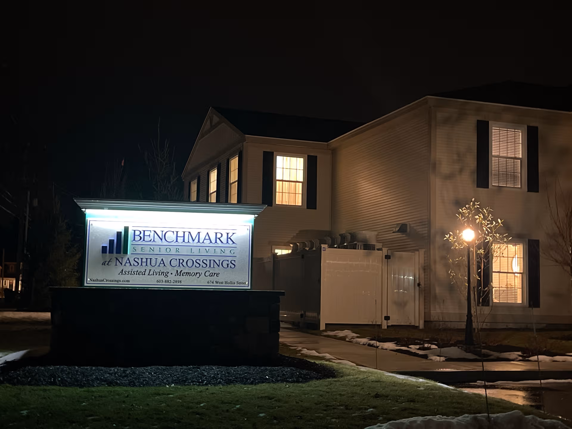 Exterior view of Benchmark Senior Living at Nashua Crossings with illuminated sign.