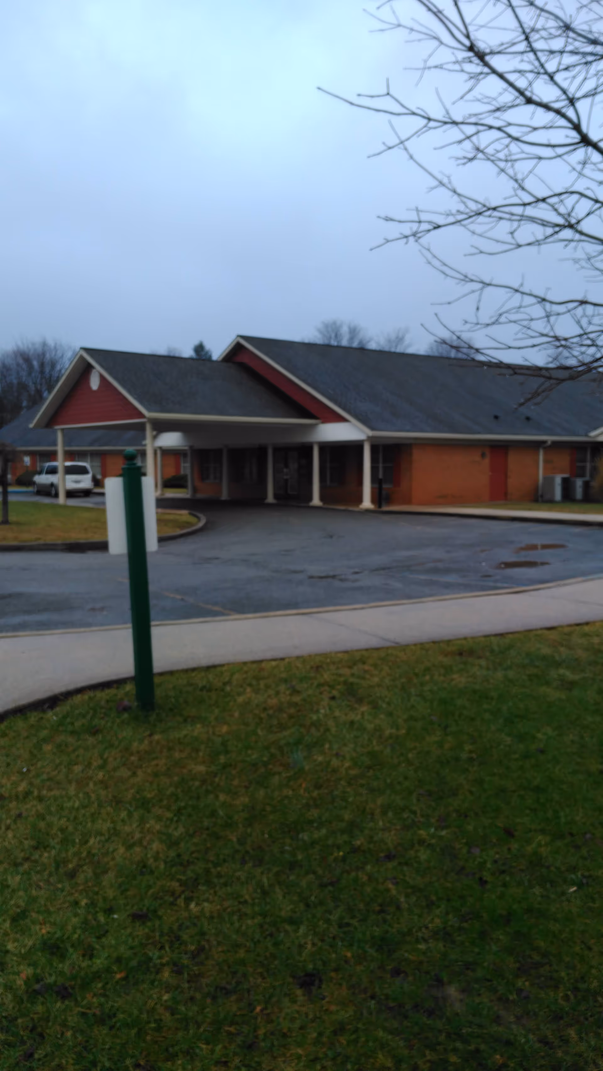 Exterior view of Mountain Memories facility with brick walls, entrance canopy, and driveway.