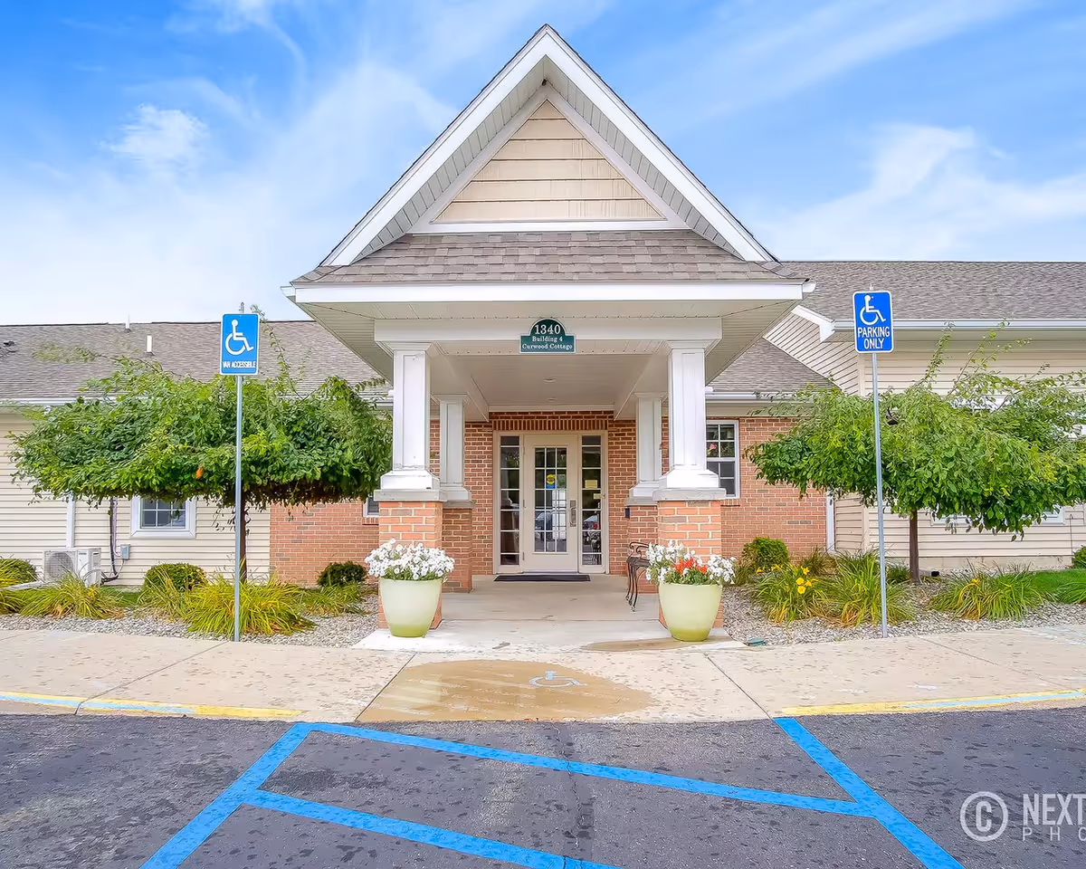 Entrance to Oliver Woods Assisted Living and Memory Care with brick front and handicap parking.