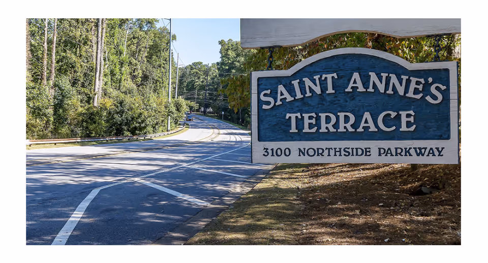 Curved road with trees leads to Saint Anne's Terrace sign by the entrance