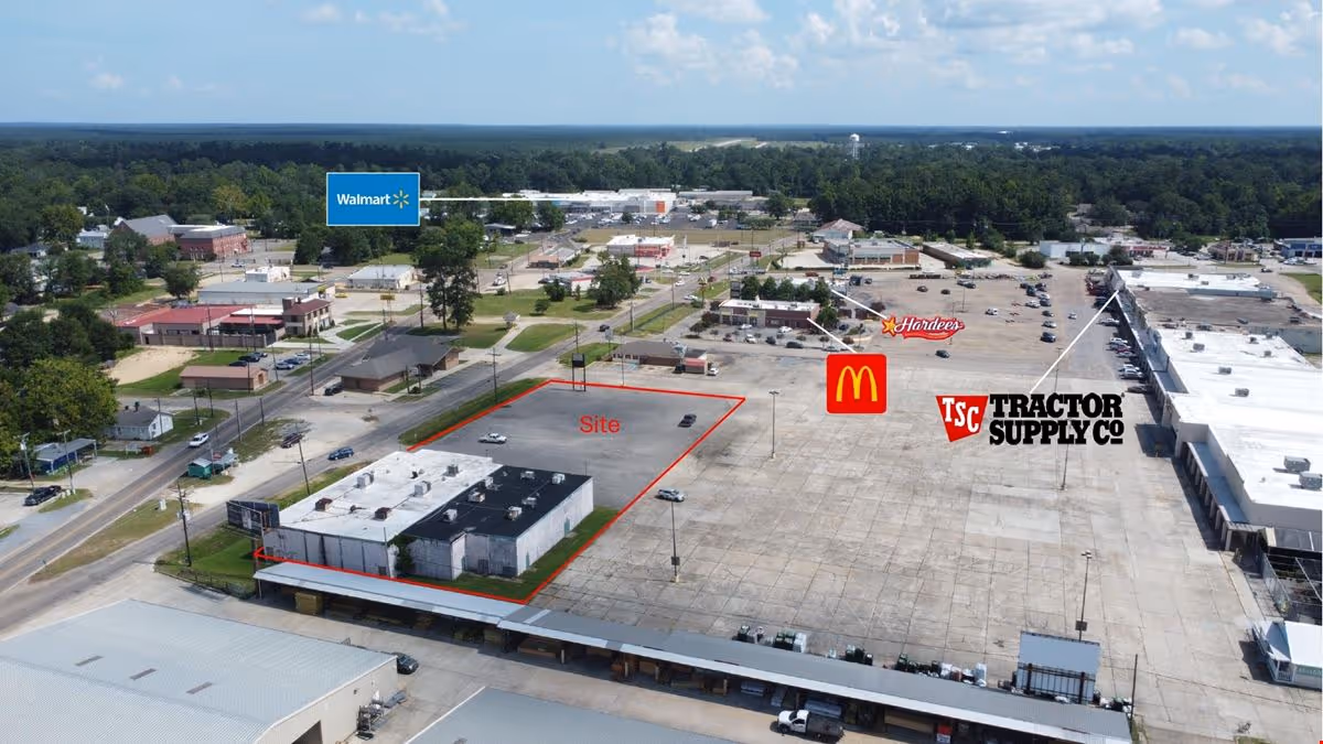 Aerial view of a commercial plaza parking lot with a site outline near Walmart and McDonald's.