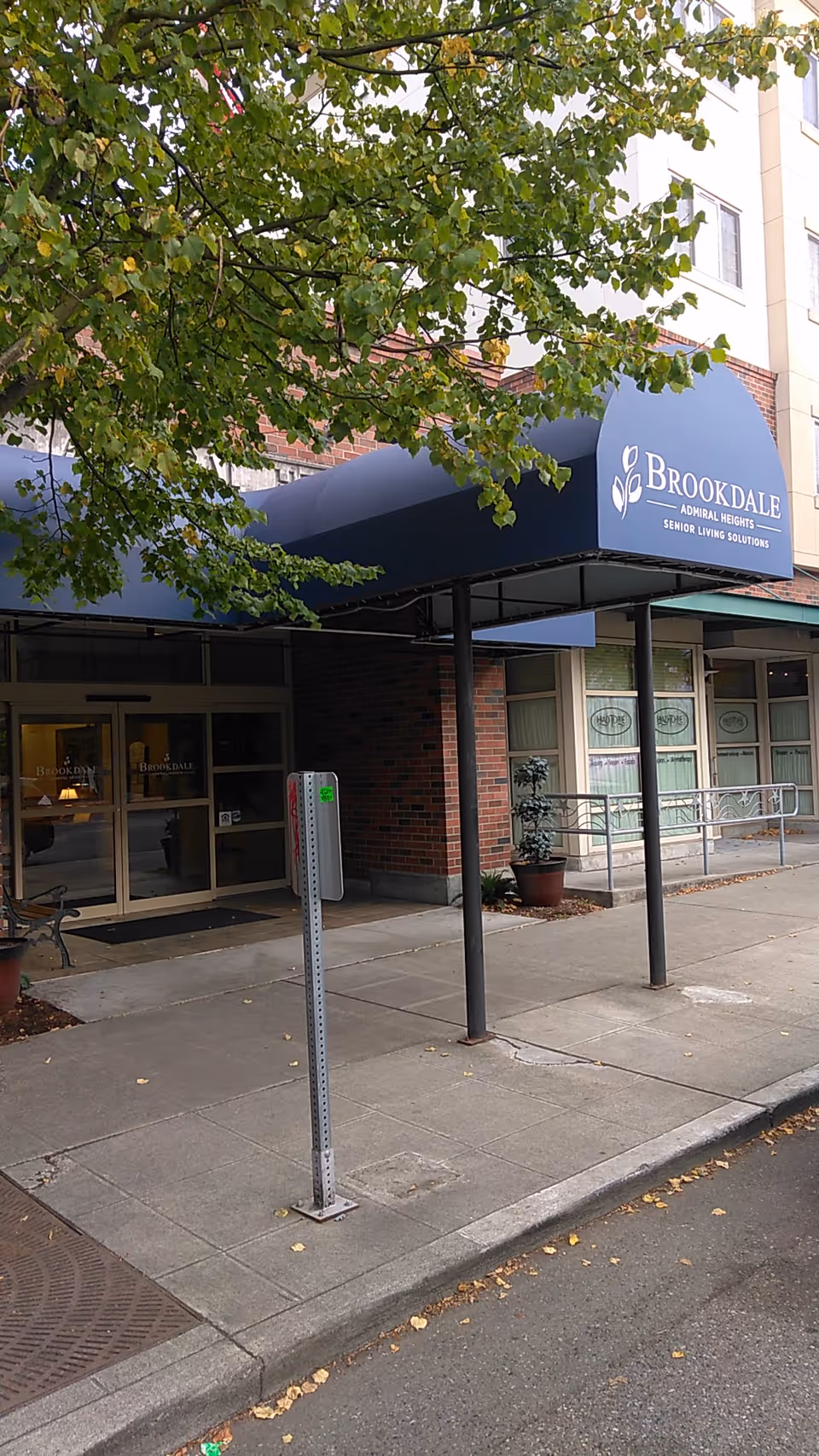 Exterior view of Brookdale Admiral Heights entrance with blue canopy and sign.