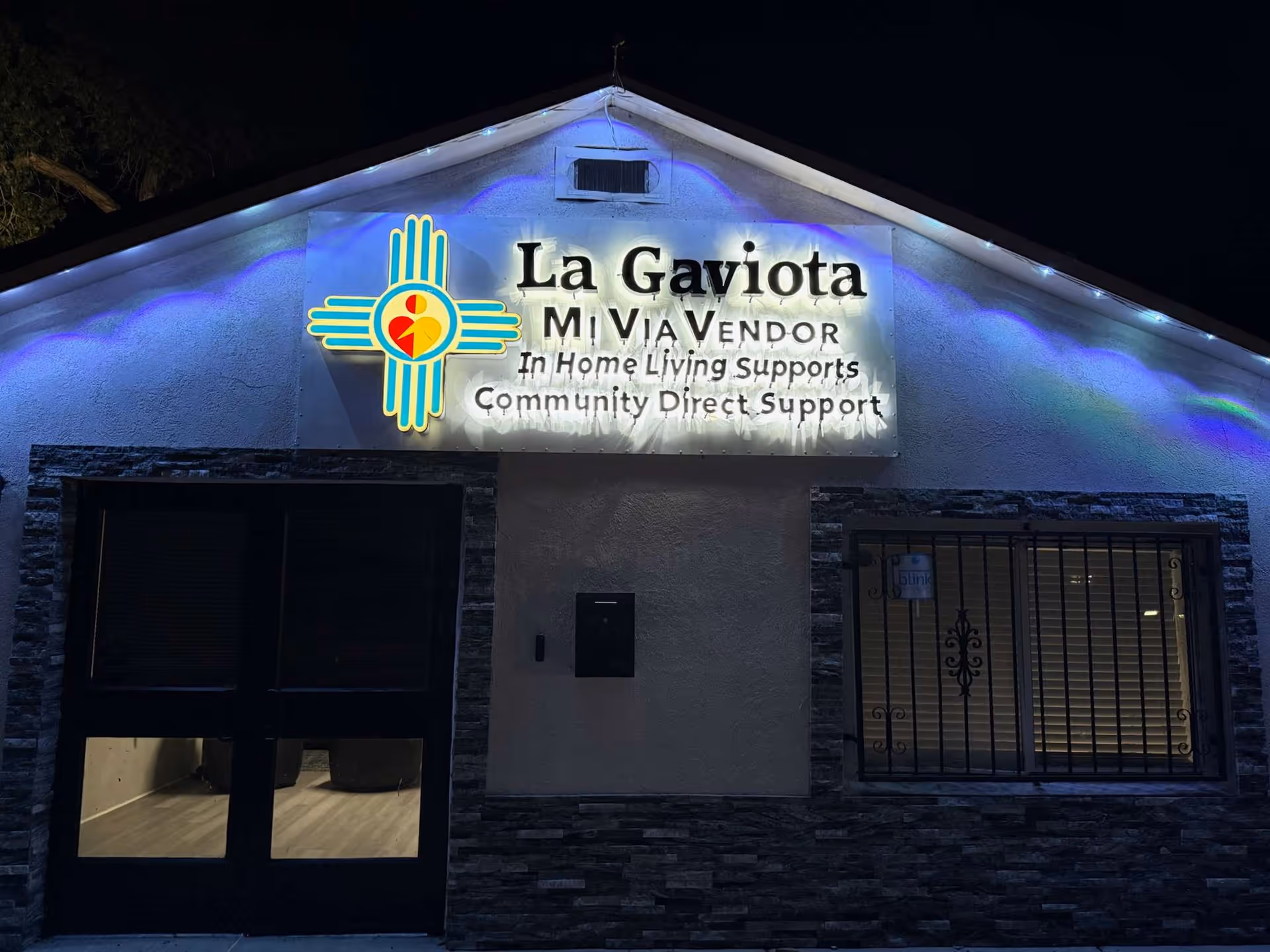 Nighttime exterior of La Gaviota NM building with illuminated sign.