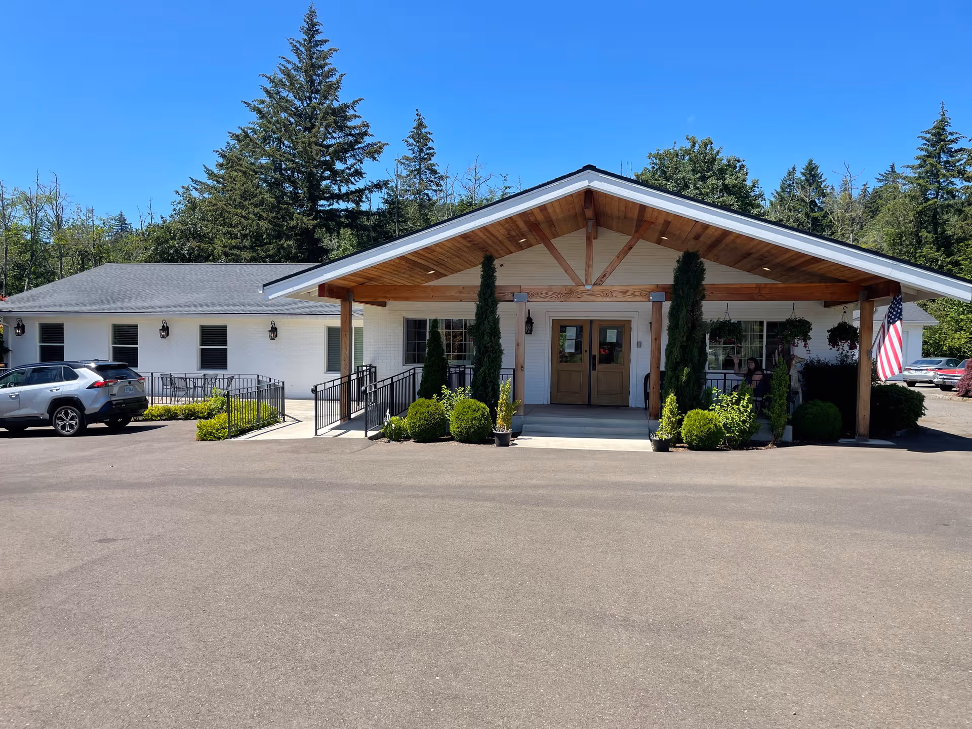 Aveena Memory Care front building with a covered entry, parking lot, and landscaped shrubs.