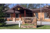 Exterior view of a senior living facility entrance with a stone sign.