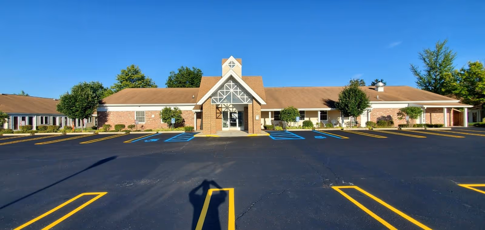 Villa Marie senior living facility, a single-story brick building with a glass entry and parking.
