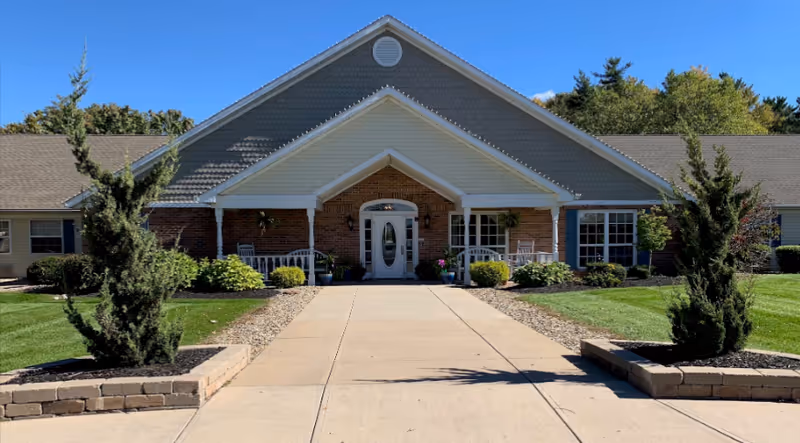 Front view of Arden Courts Bath senior living facility with a walkway and landscaped entry.