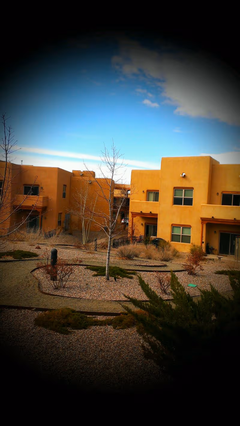 Exterior view of The Montecito of Santa Fe, tan stucco buildings with desert landscaping.