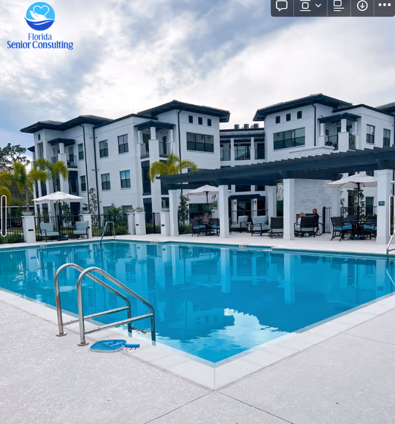 Outdoor pool area with white buildings and lounge seating.