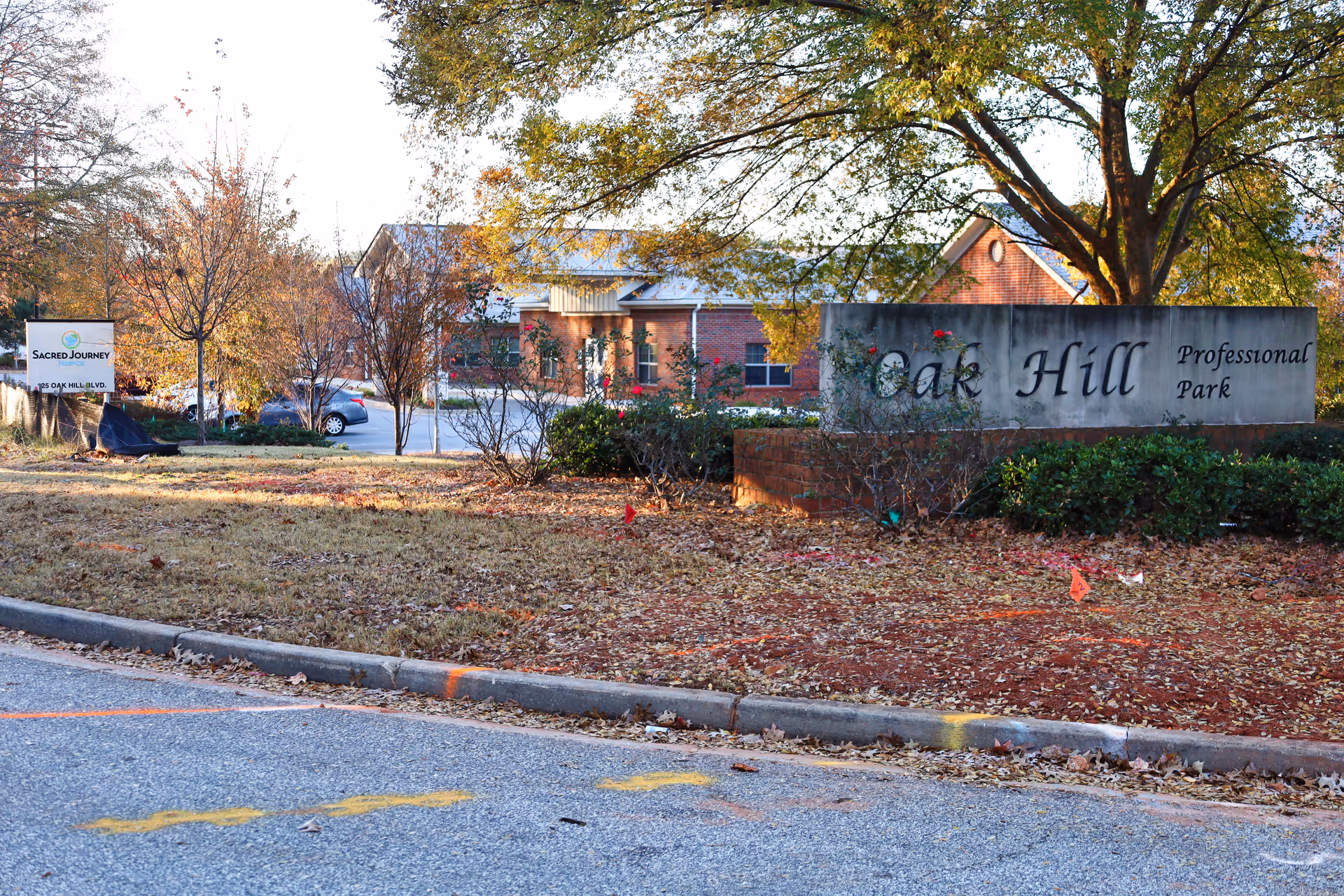 Exterior view of Sacred Journey Hospice sign and Oak Hill Professional Park building in Newnan, Georgia.