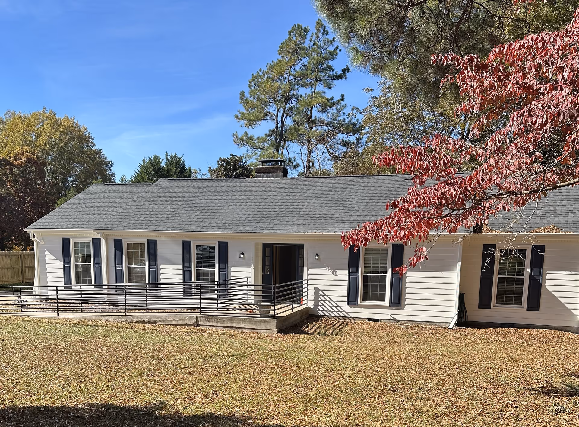 Single-story senior living facility exterior with a ramp and dark blue shutters.