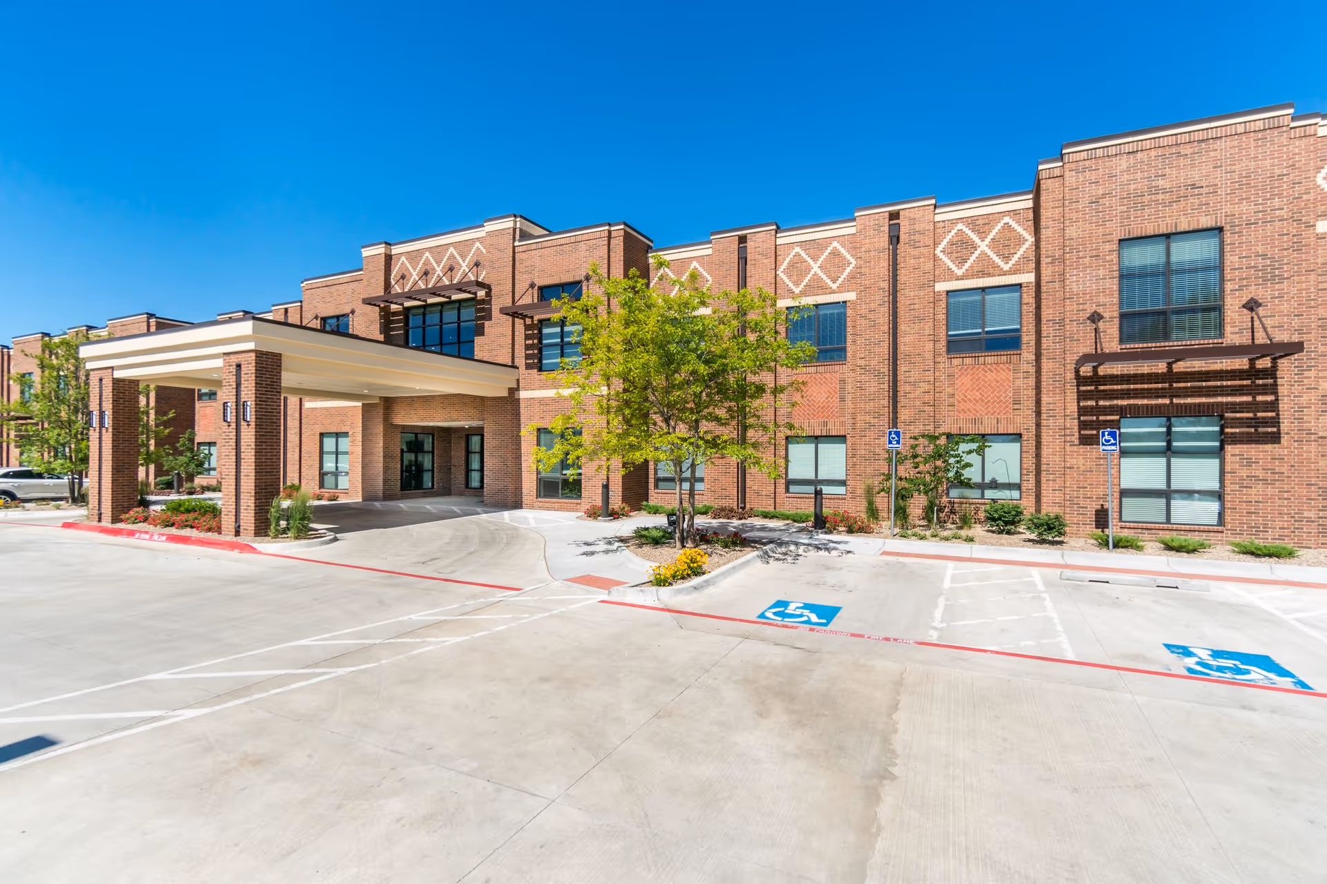 Exterior view of Ware Memorial Care Center's brick building with entrance canopy and parking.