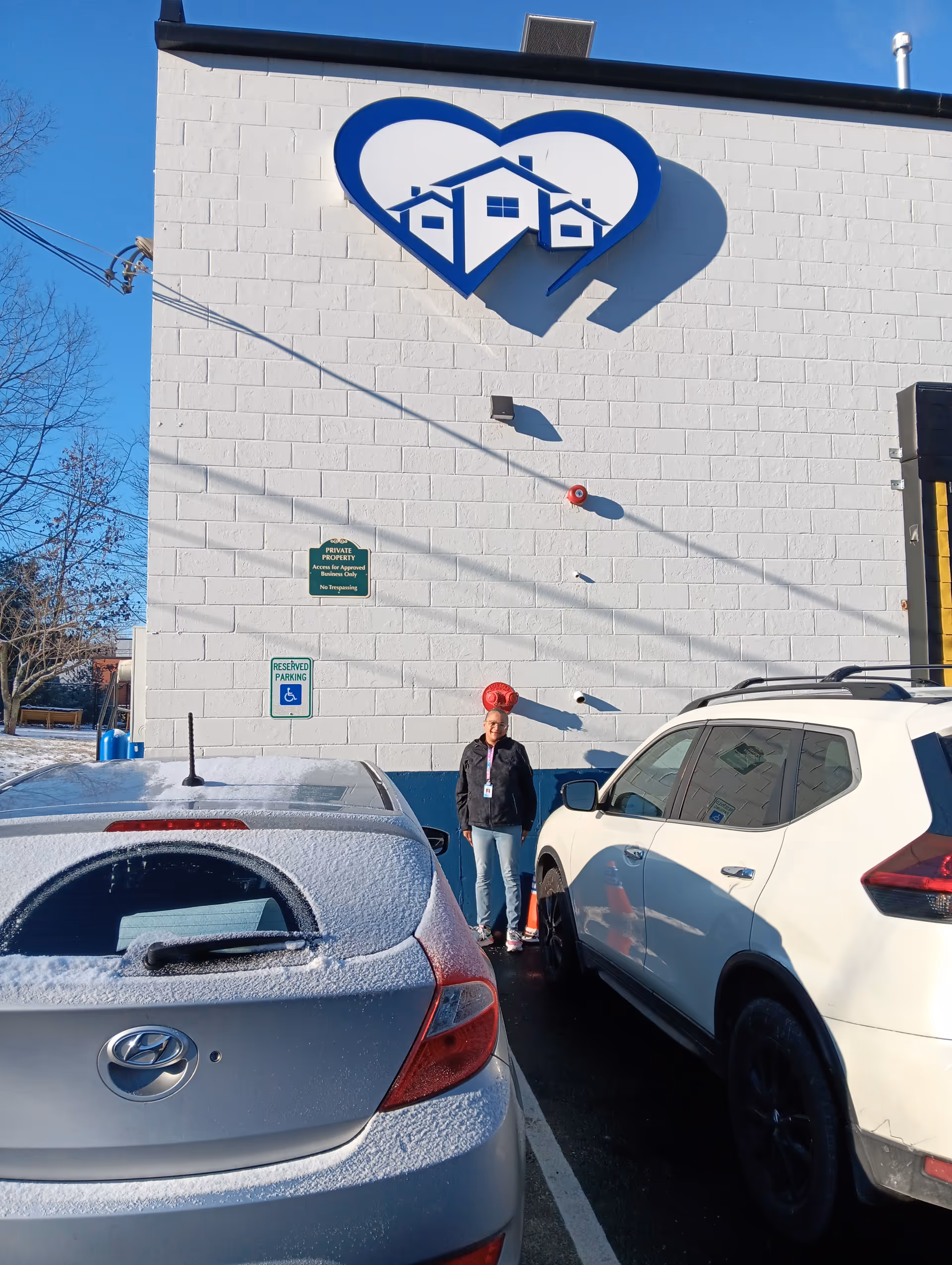 Exterior view of ABBA Home Care LLC building with heart-shaped logo and parked cars.
