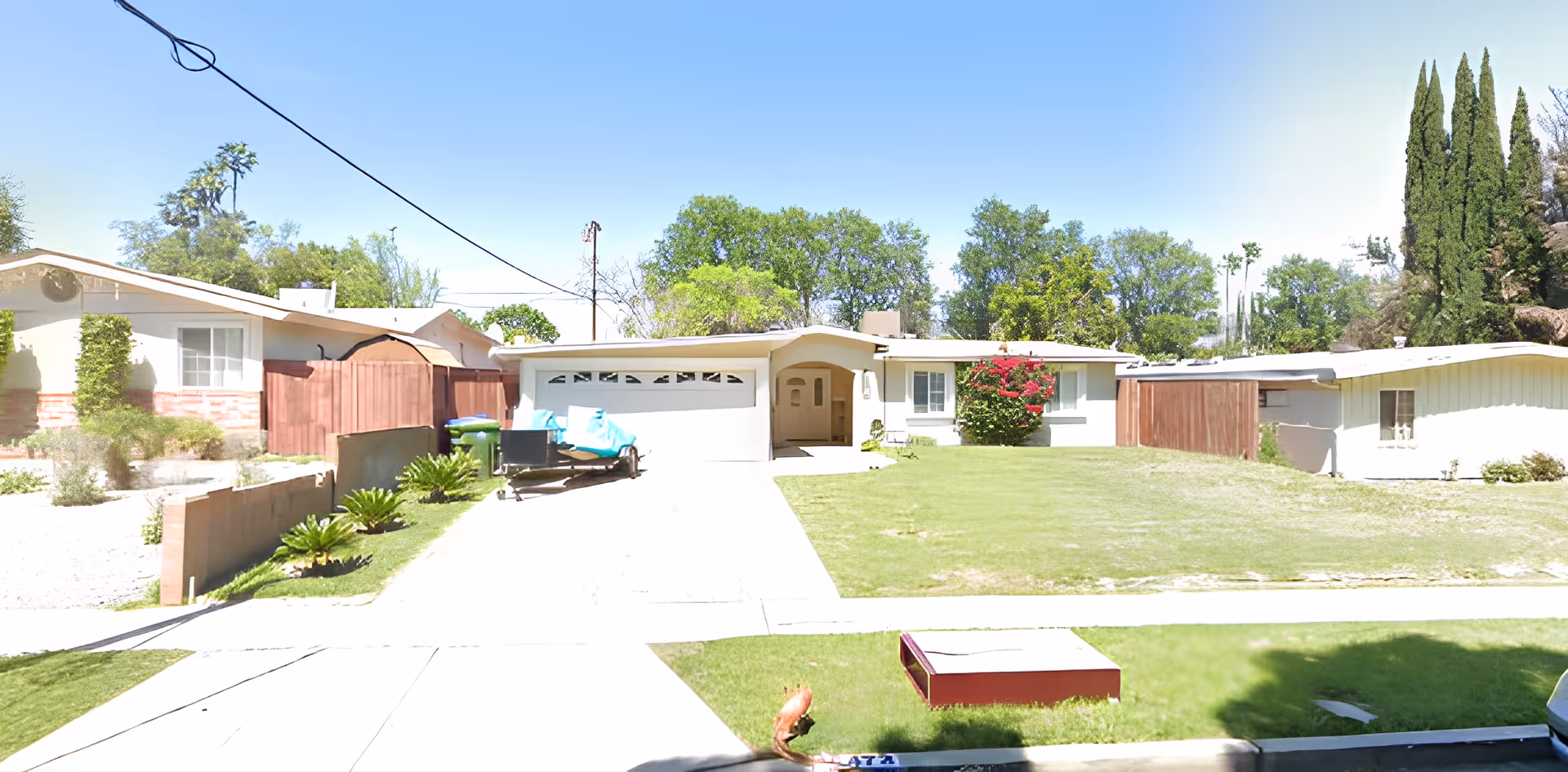 Front exterior of a single-story suburban house with a driveway, garage, and lawn.