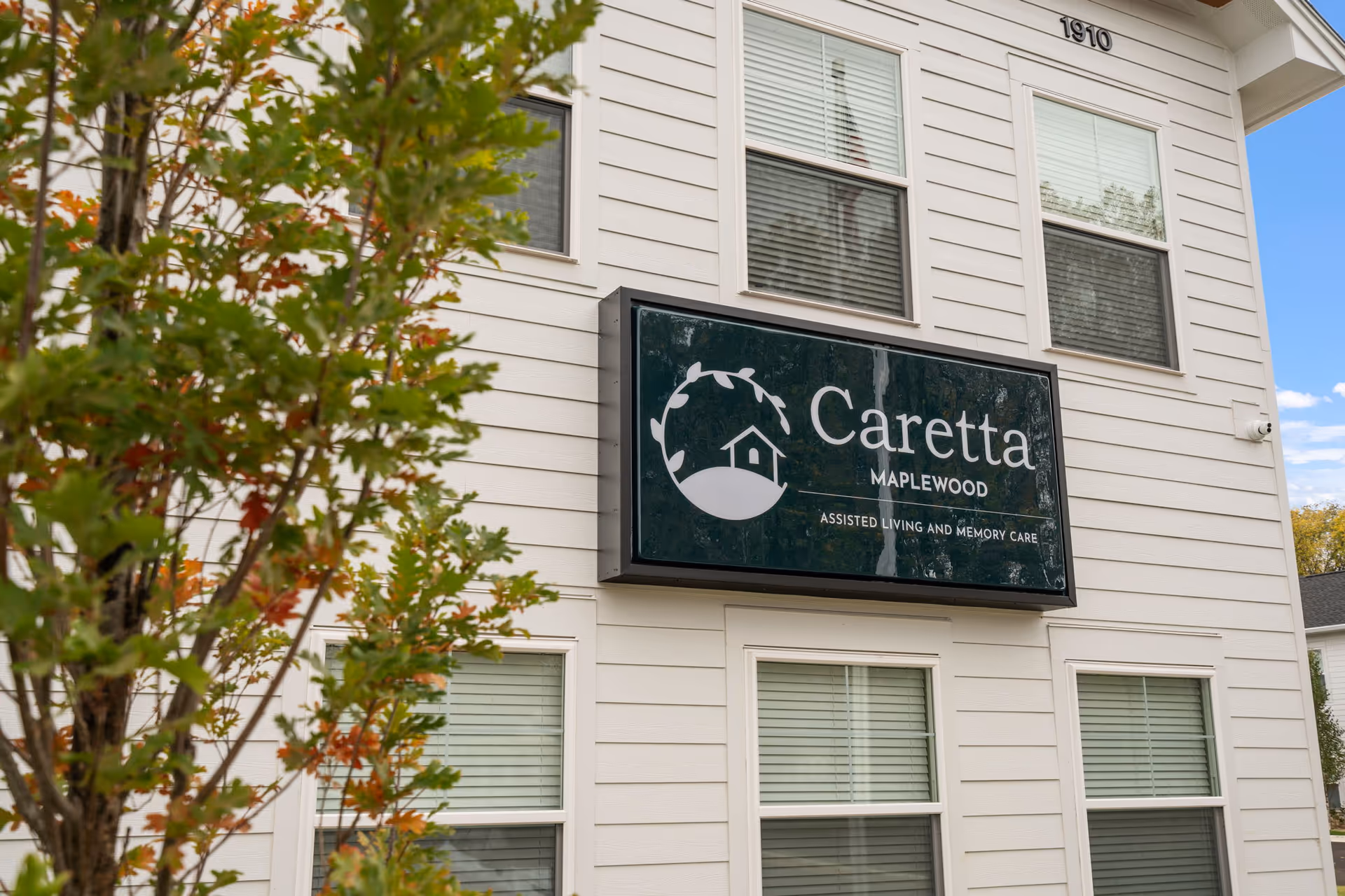 Exterior view of a Caretta Maplewood senior living building with a prominent sign.
