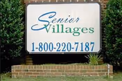 Exterior sign reading Senior Villages with phone number in front of a brick base.