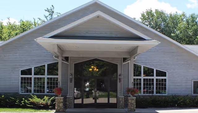 Front entrance of North Crest Assisted Living with glass doors and a covered portico.