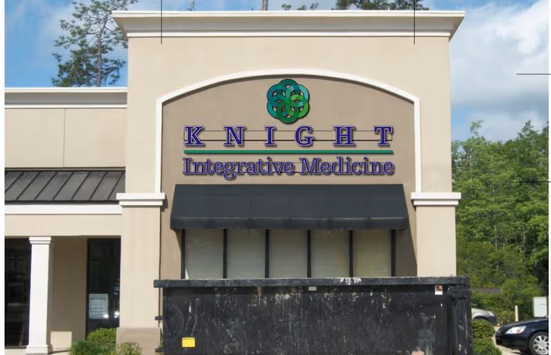 Front exterior of Knight Integrative Medicine building with arched sign and black awning.