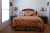 A neatly made bed with two nightstands and lamps in a cozy bedroom.