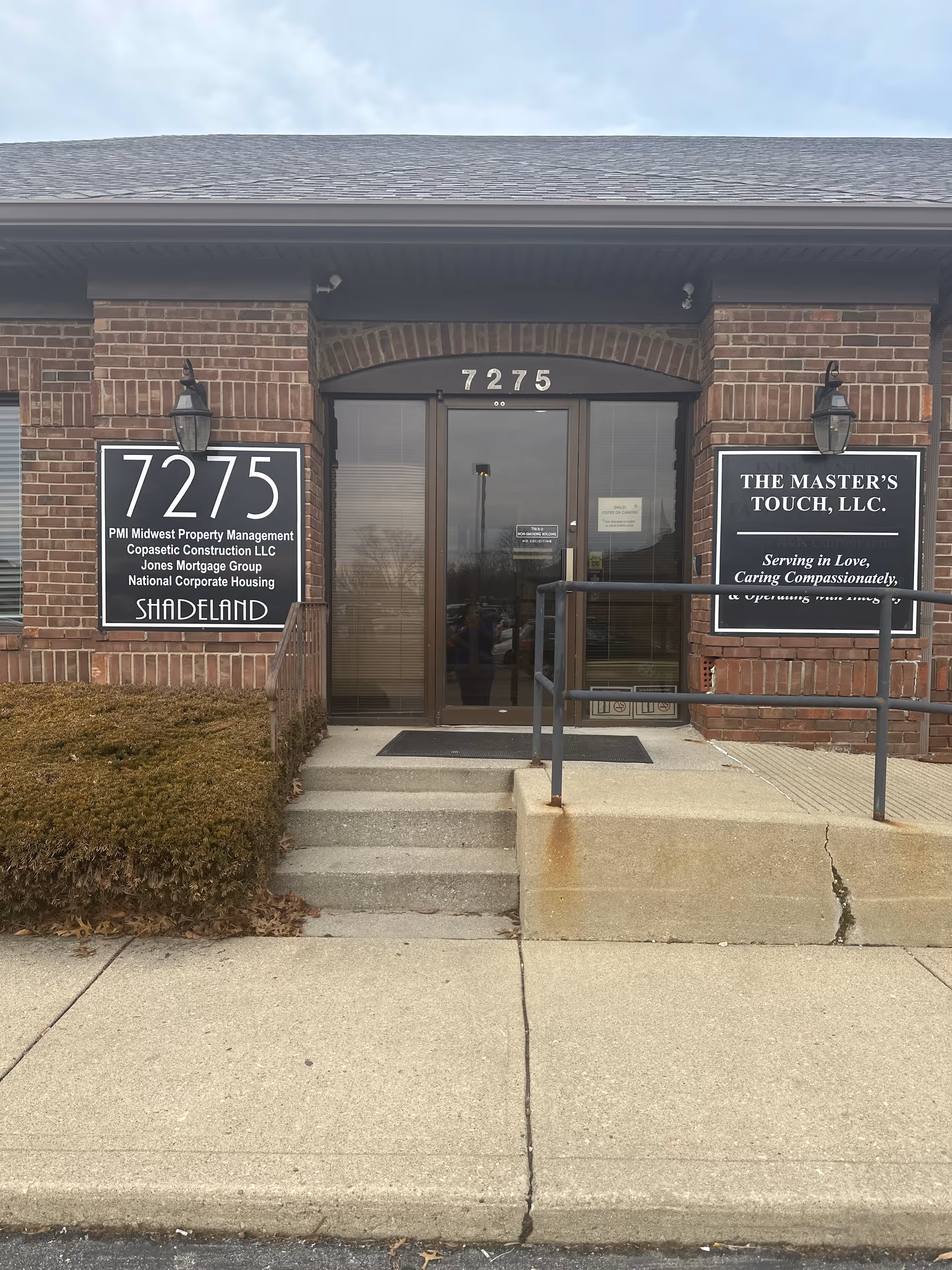 Brick building entrance with address 7275 and signs for The Master's Touch, LLC.