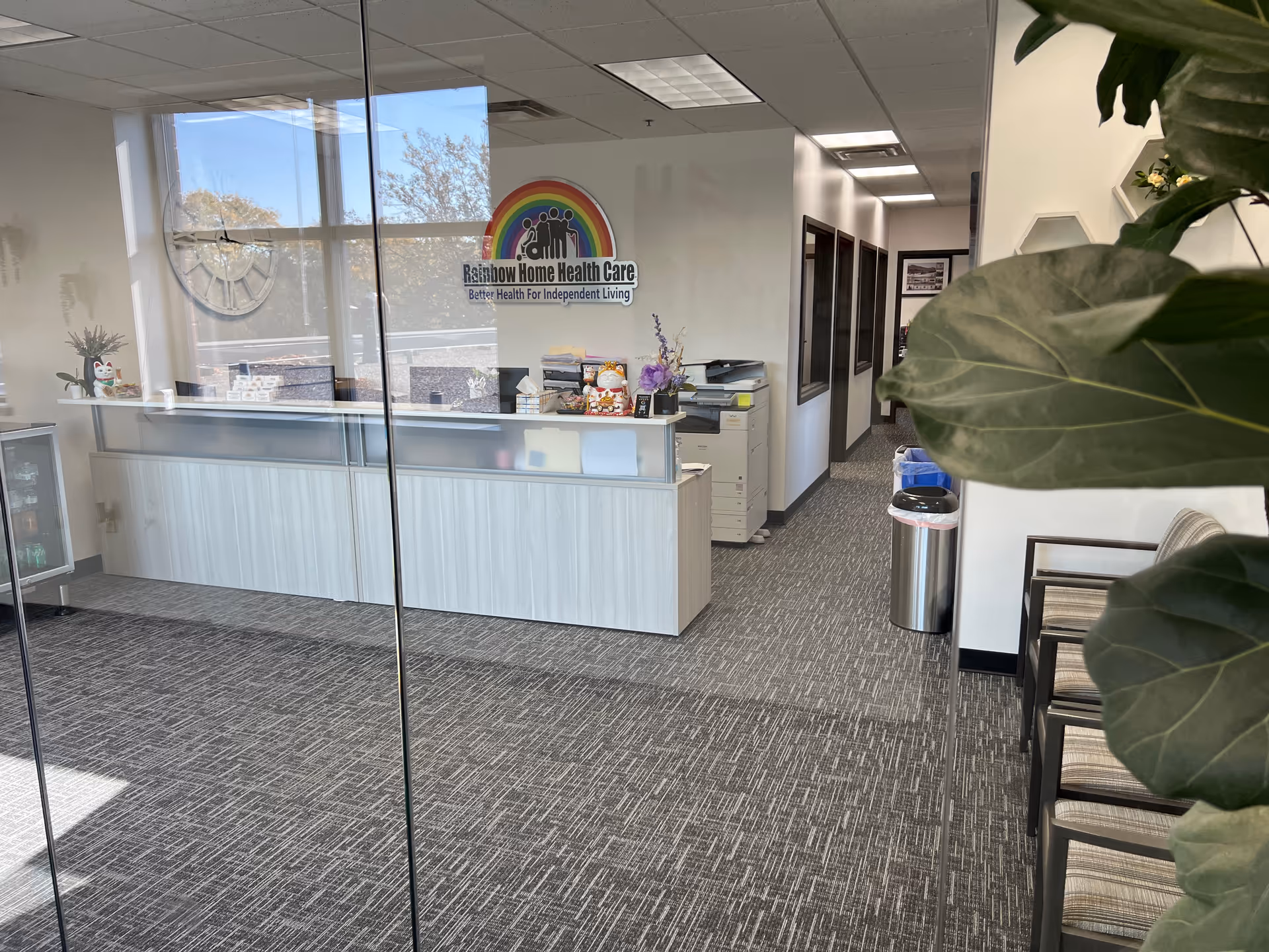 Reception area inside Rainbow Home Health Care with glass walls and logo.