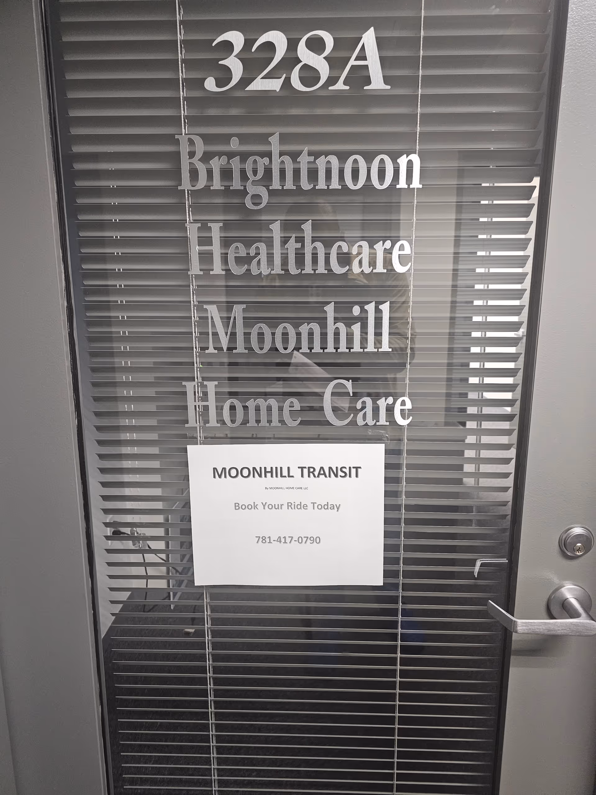 Glass door with blinds displaying Moonhill Home Care and Moonhill Transit signage.