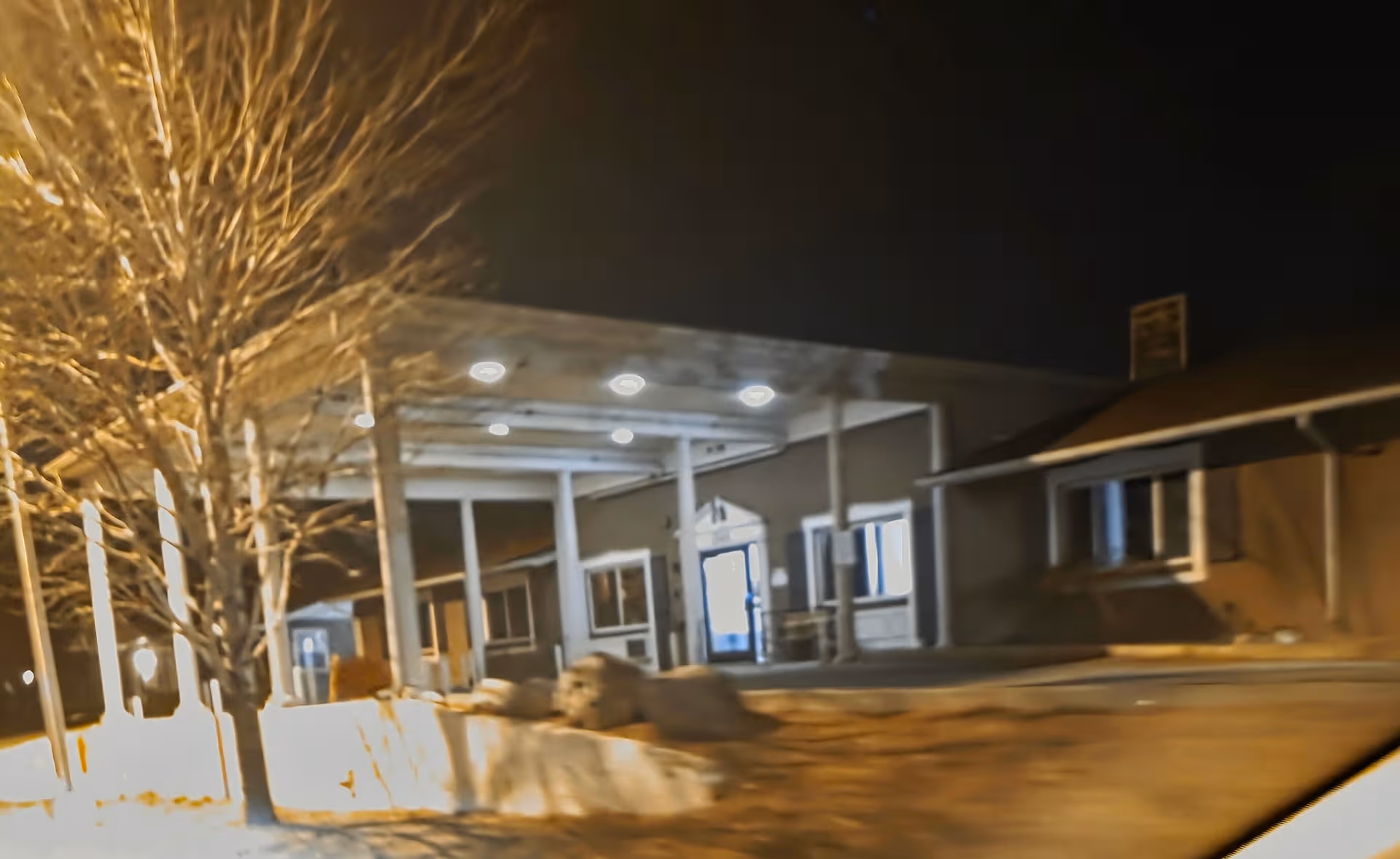 Nighttime view of Colonial Columns LTC building exterior with a covered front entrance.