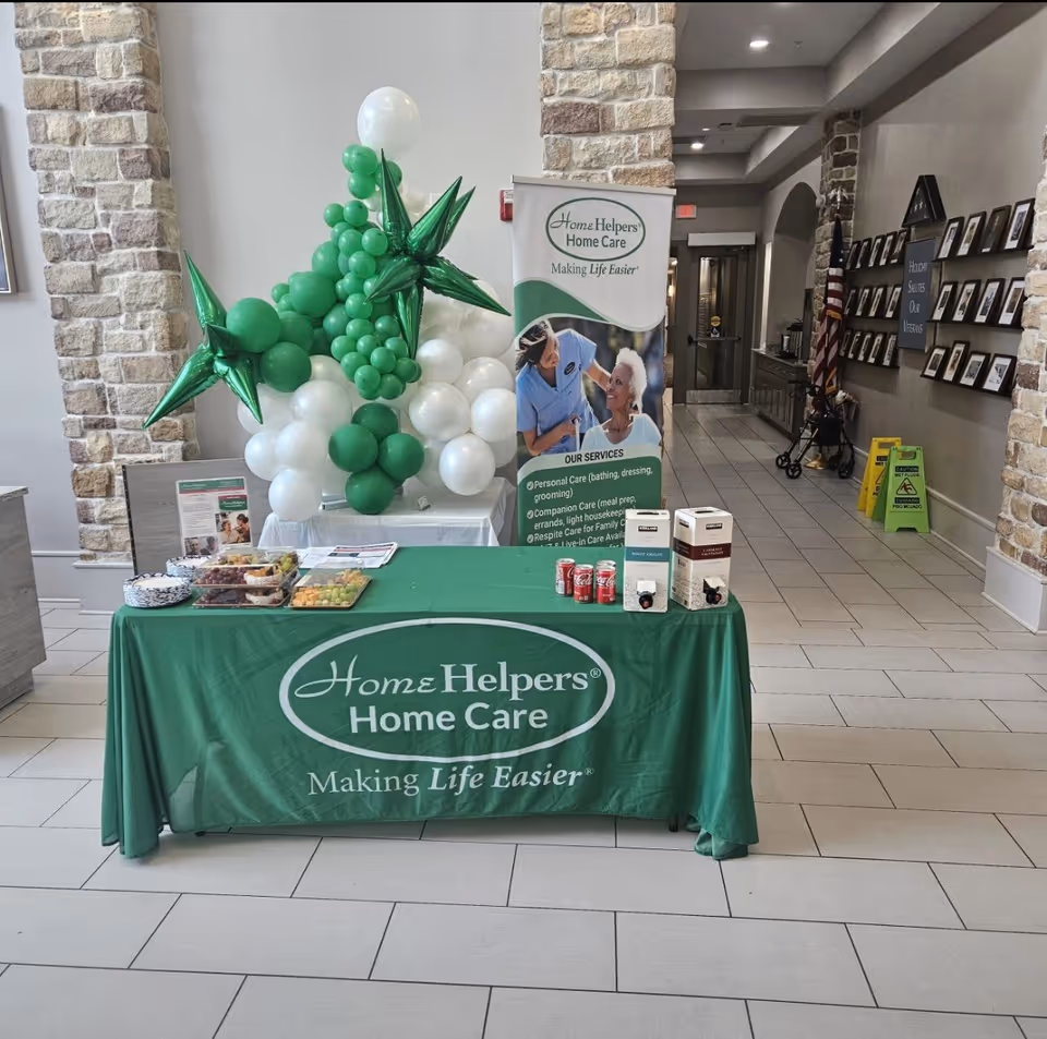Lobby display table for Home Helpers Home Care with balloons and banner.