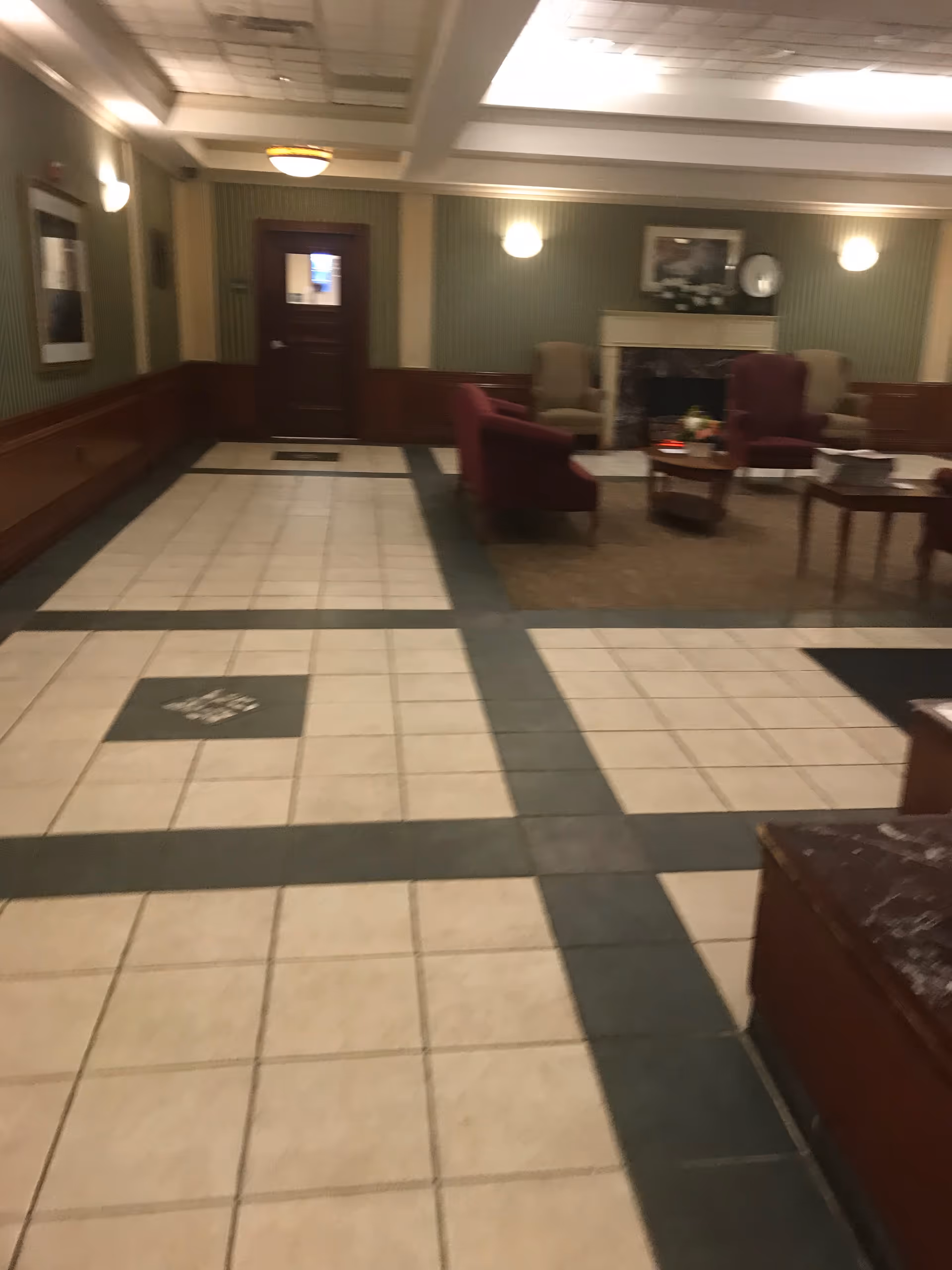 Regal Heights lobby with tile floor, seating, and a fireplace.