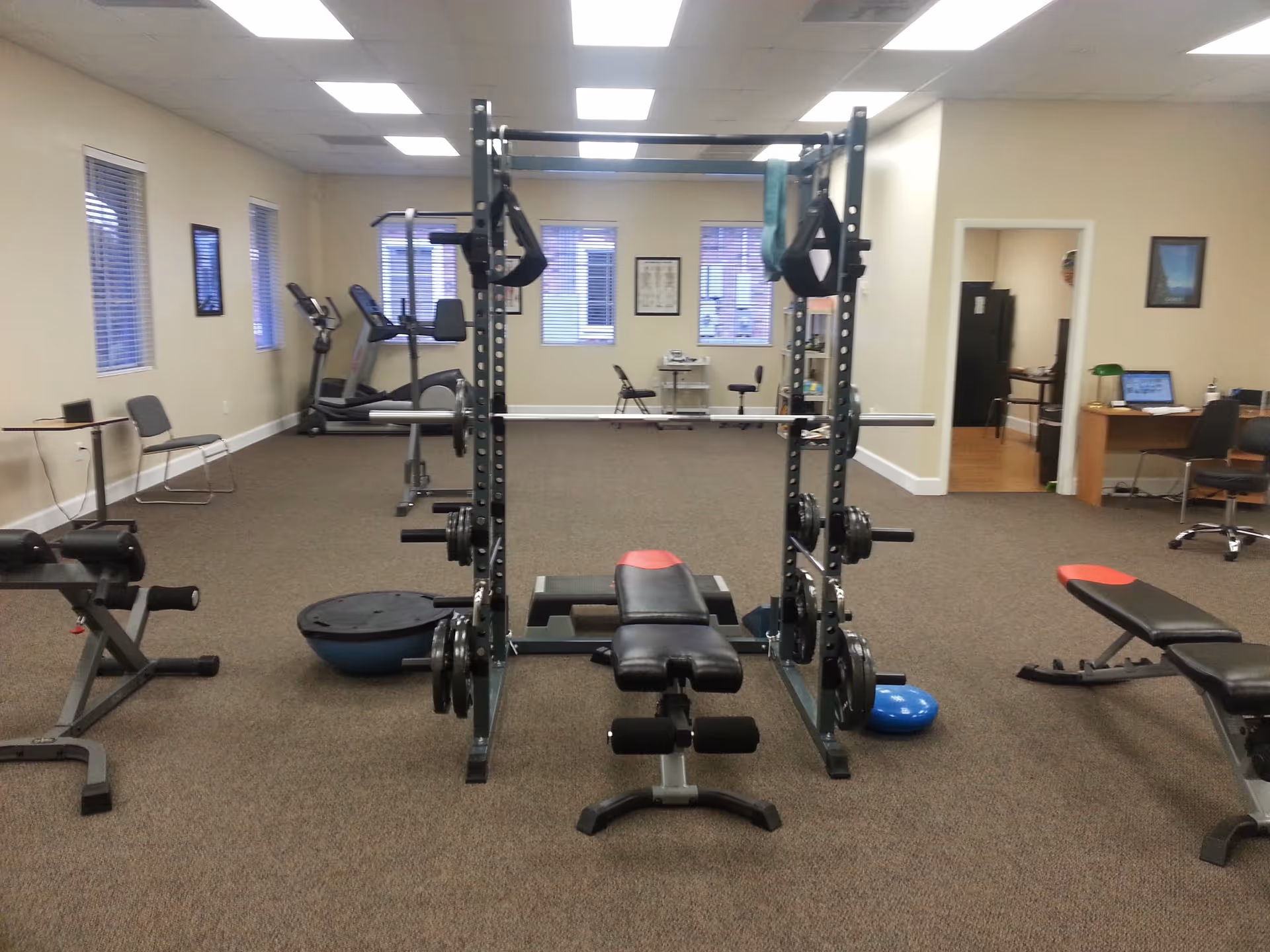 Spacious interior gym with weight rack, bench, and cardio equipment