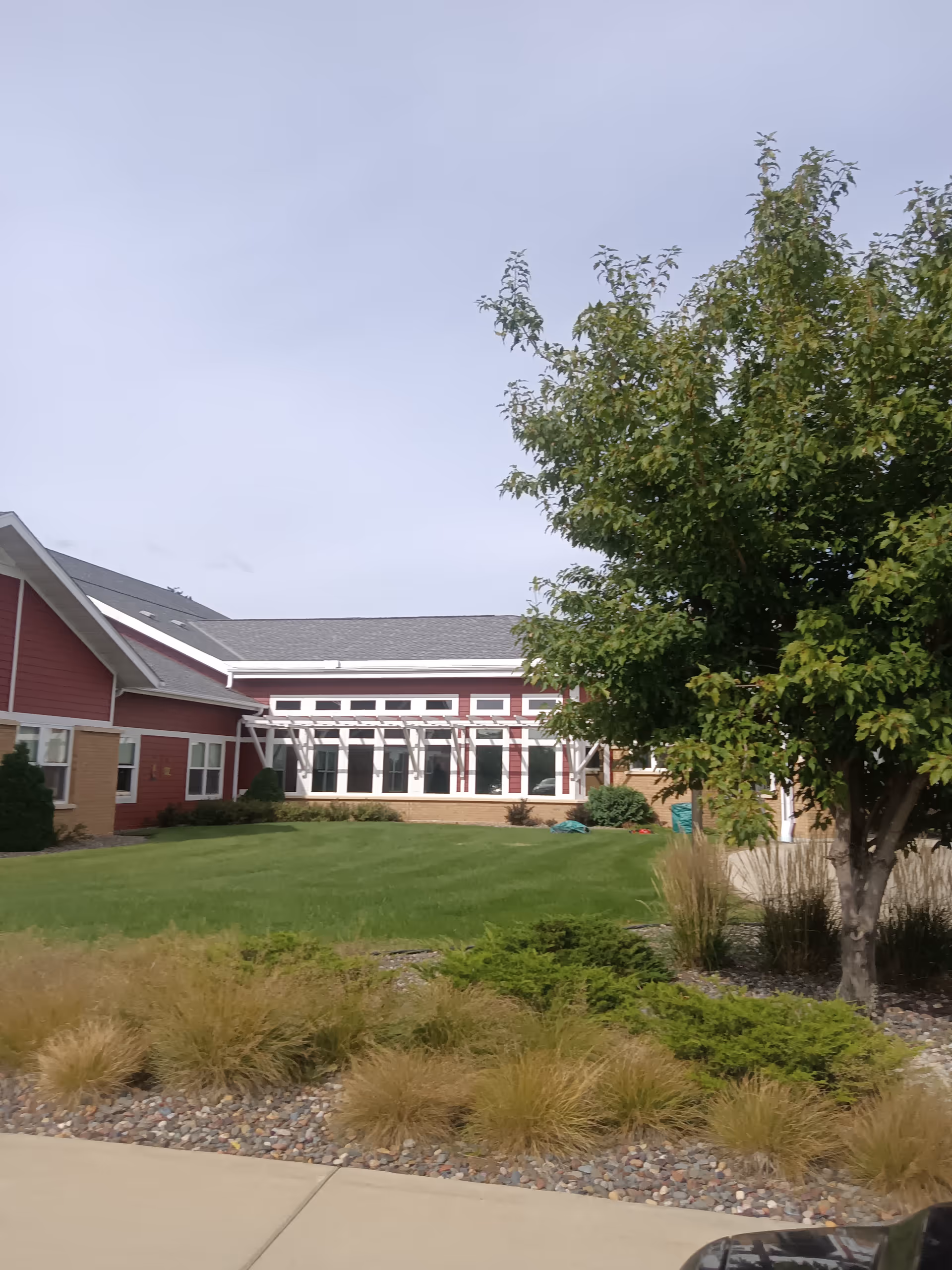 Exterior view of Kitty Rhoades Memorial Memory Care Center with red building.