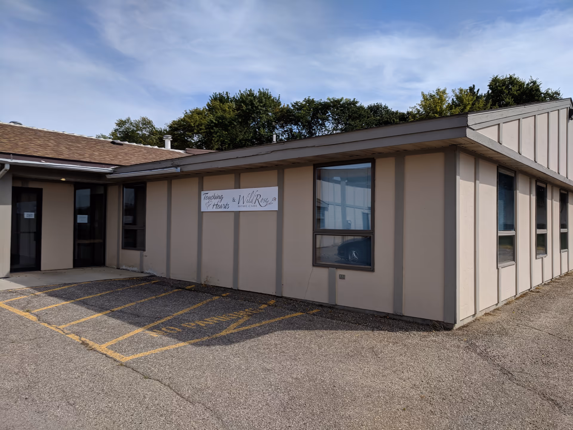Single-story building with a sign reading Wild Rose Home Care and a parking lot in front.