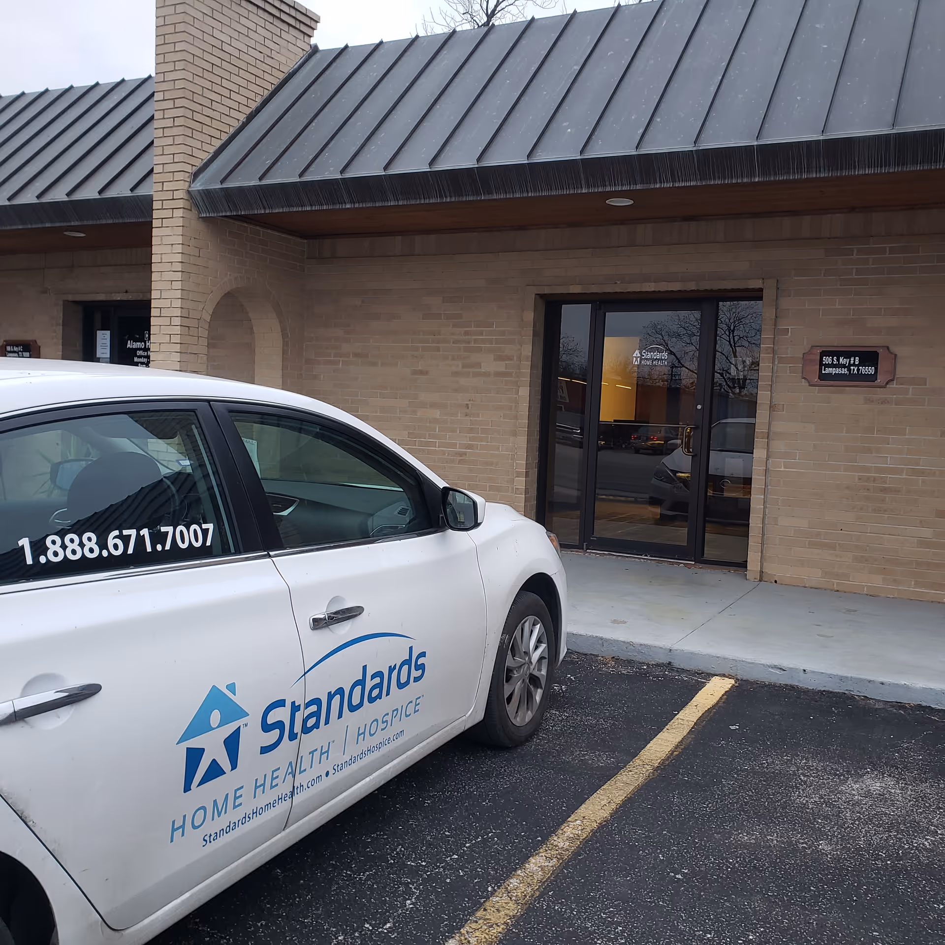 Exterior view of Standards Home Health facility with a branded car parked in front