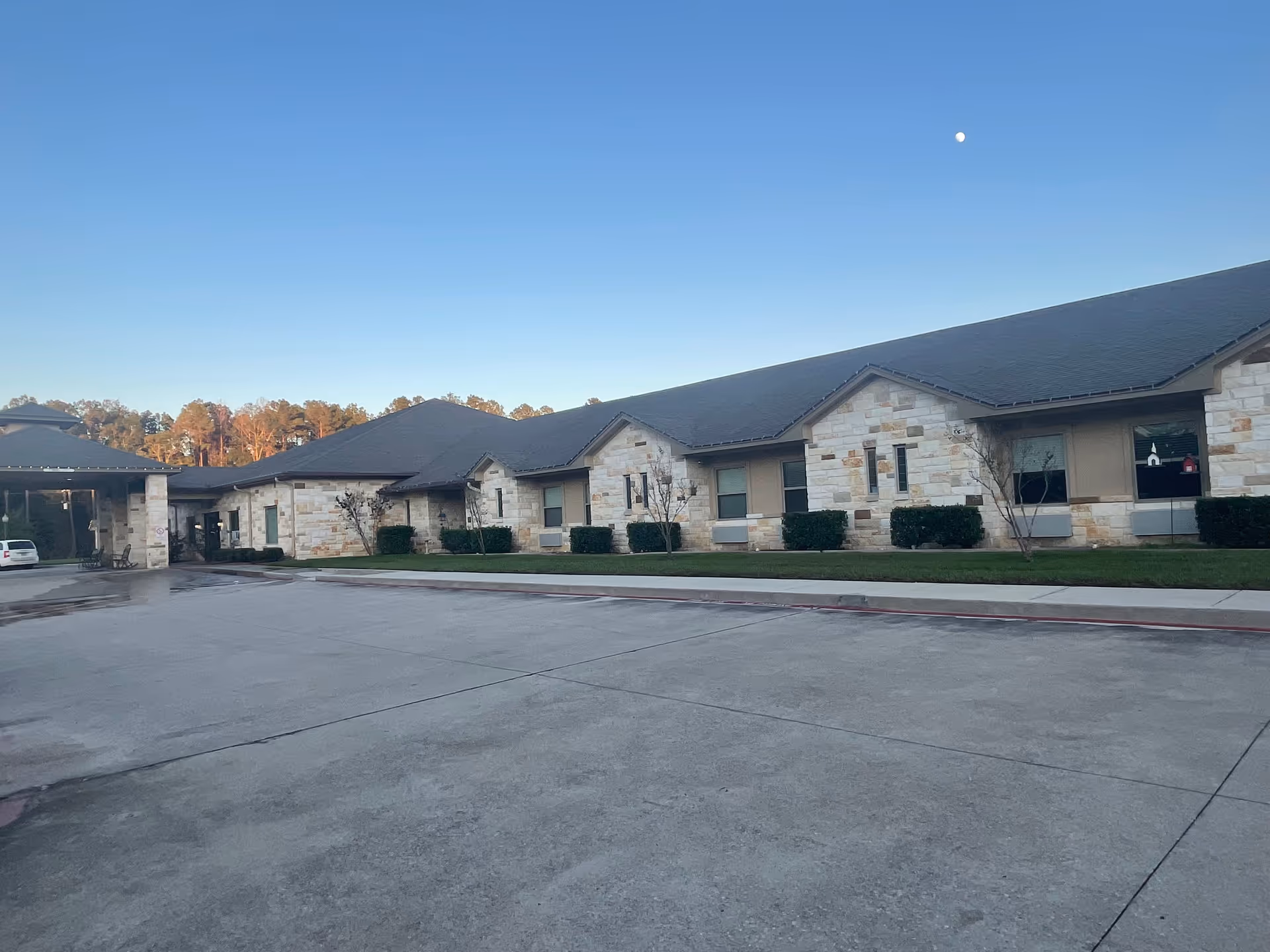 Exterior view of Shady Shores of Hemphill facility with stone facade and manicured lawn.