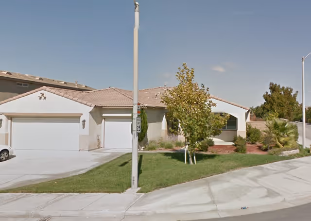 Single-story ranch-style care facility with two attached garages and a manicured front lawn.
