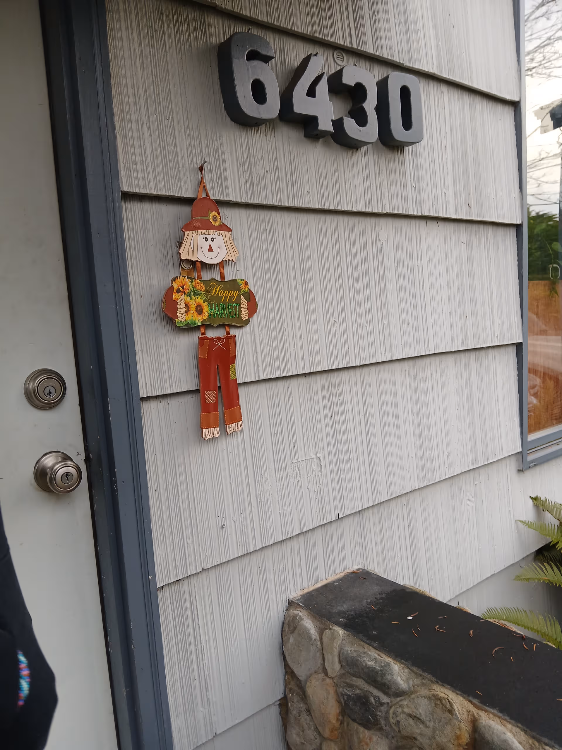 Front wall of Flower View AFH with address 6430 and a Halloween scarecrow decoration.